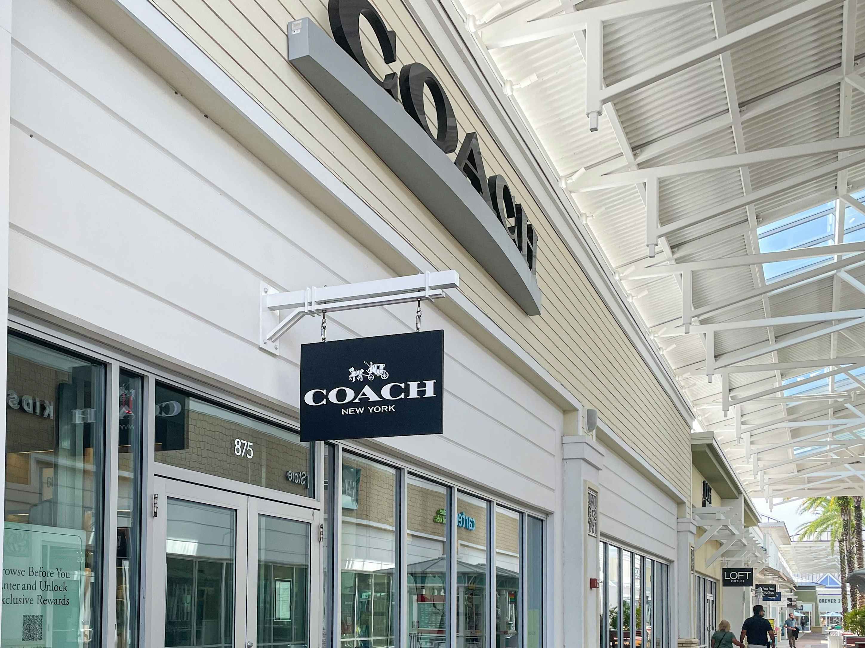 Exterior view of a coach outlet store at an outdoor outlet mall