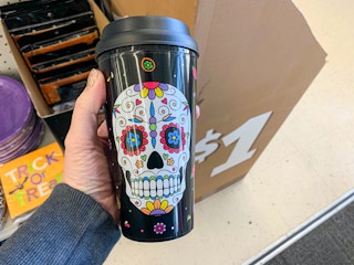 sugar skull to go tumbler held up in front of box with $1 on it
