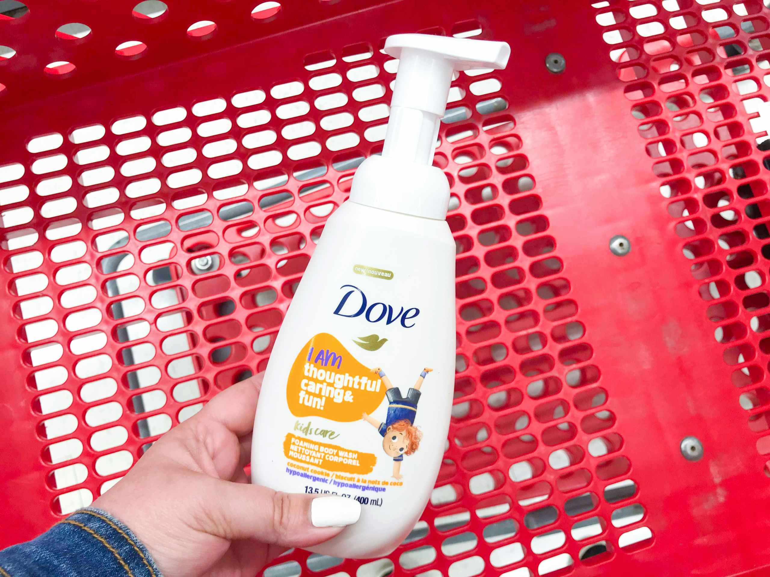 hand holding Dove kids body wash over Target shopping cart