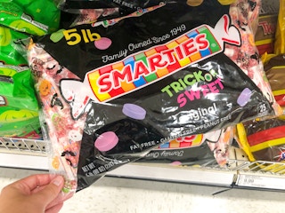 hand grabbing bag of Hallween candy off store shelf