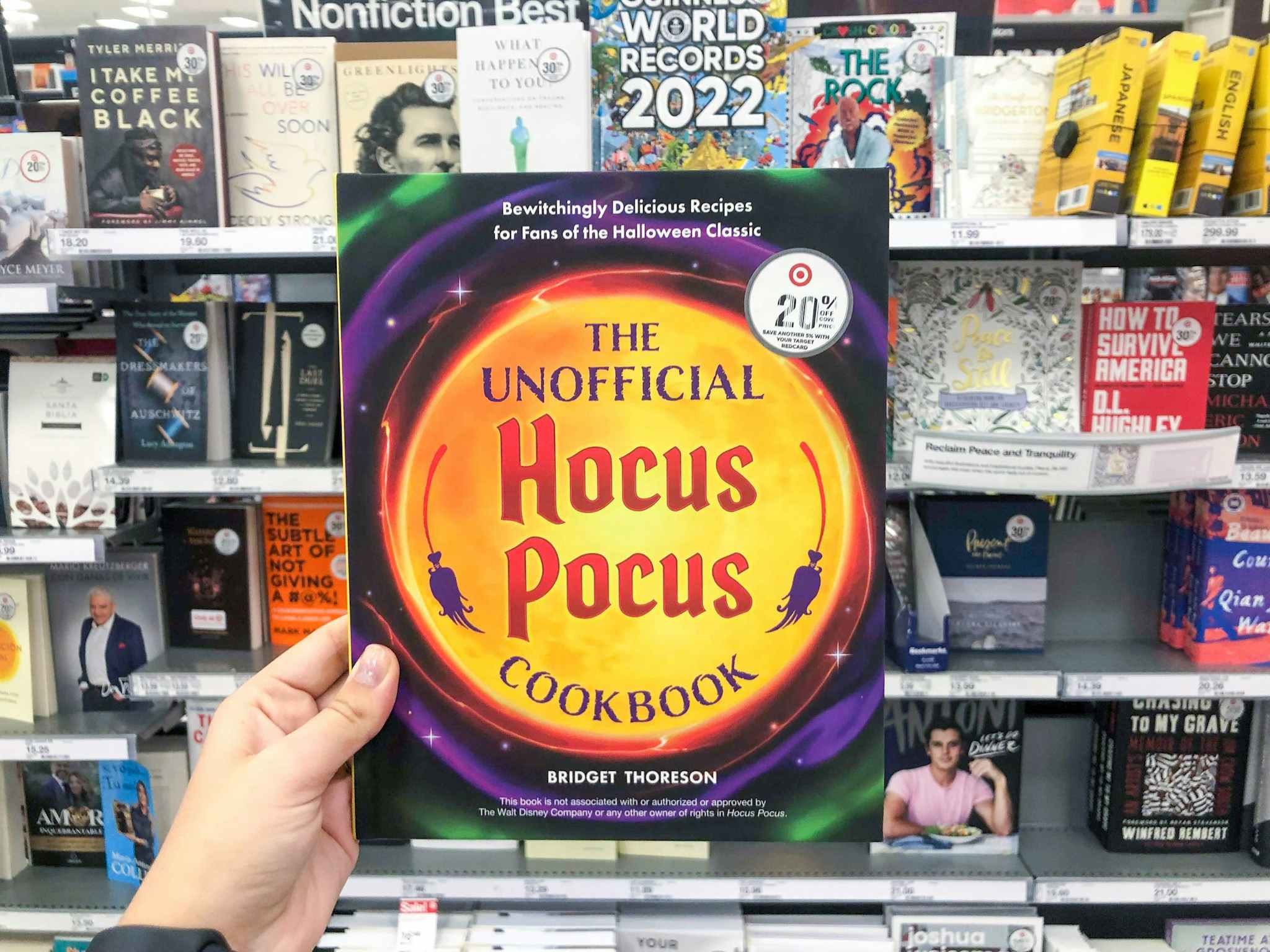hand holding a hocus pocus cookbook at target