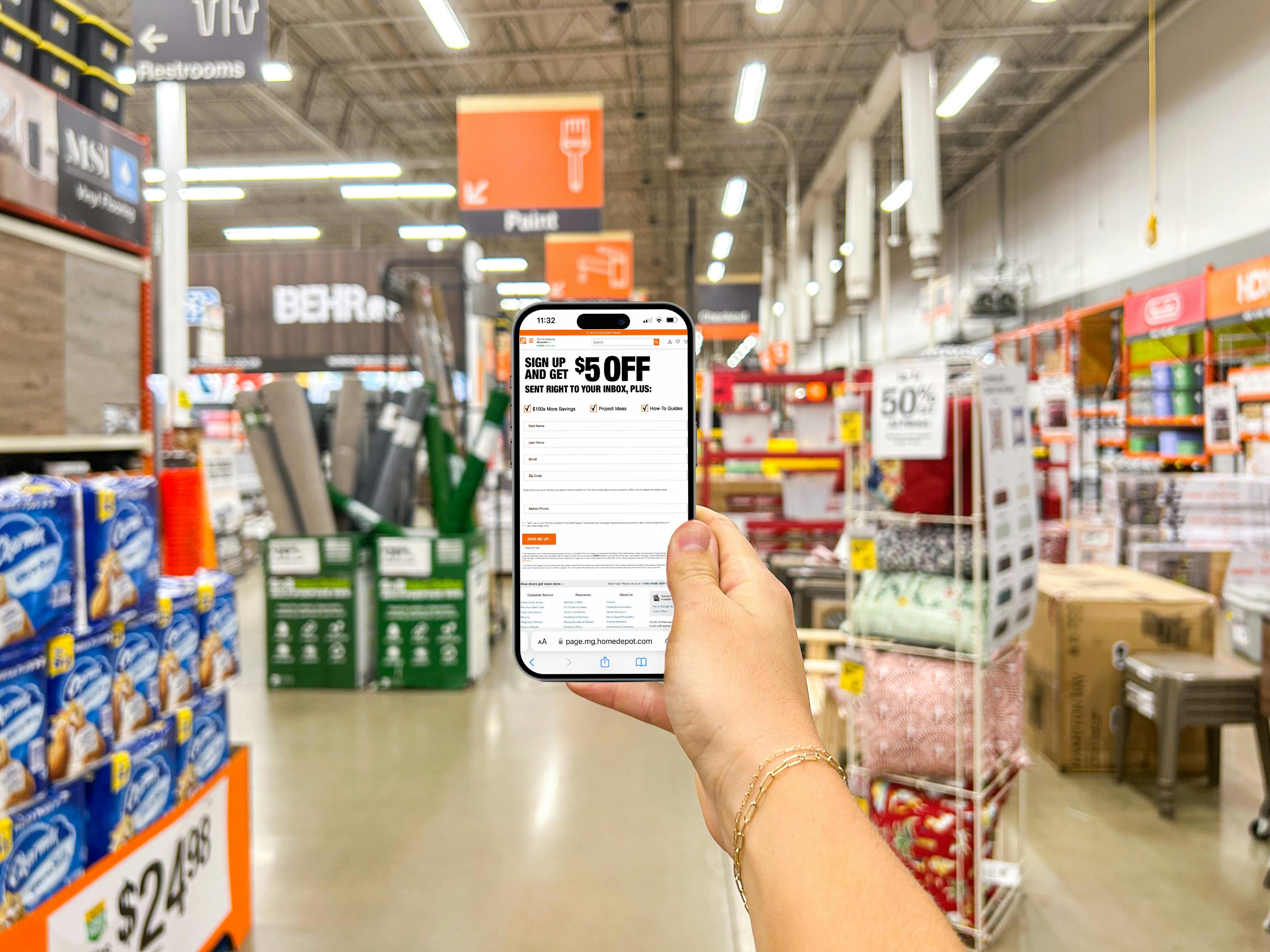 a person holding up a cell phone in home depot