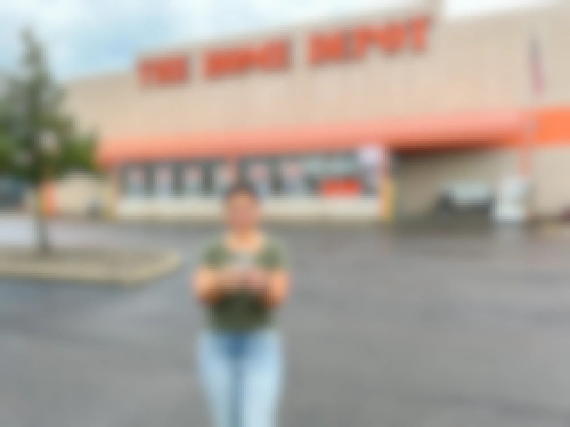 a person standing outside of home depot on their cell phone 
