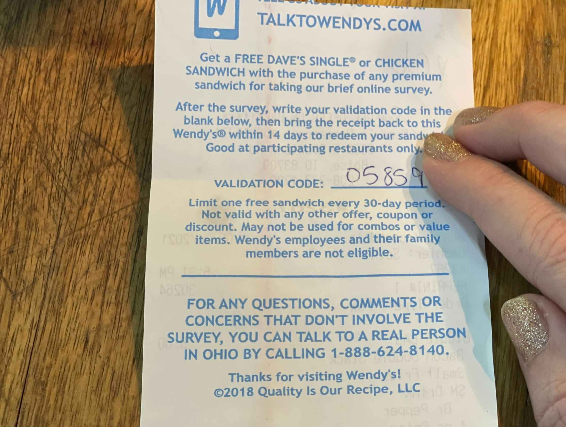 A person holding a Wendy's receipt