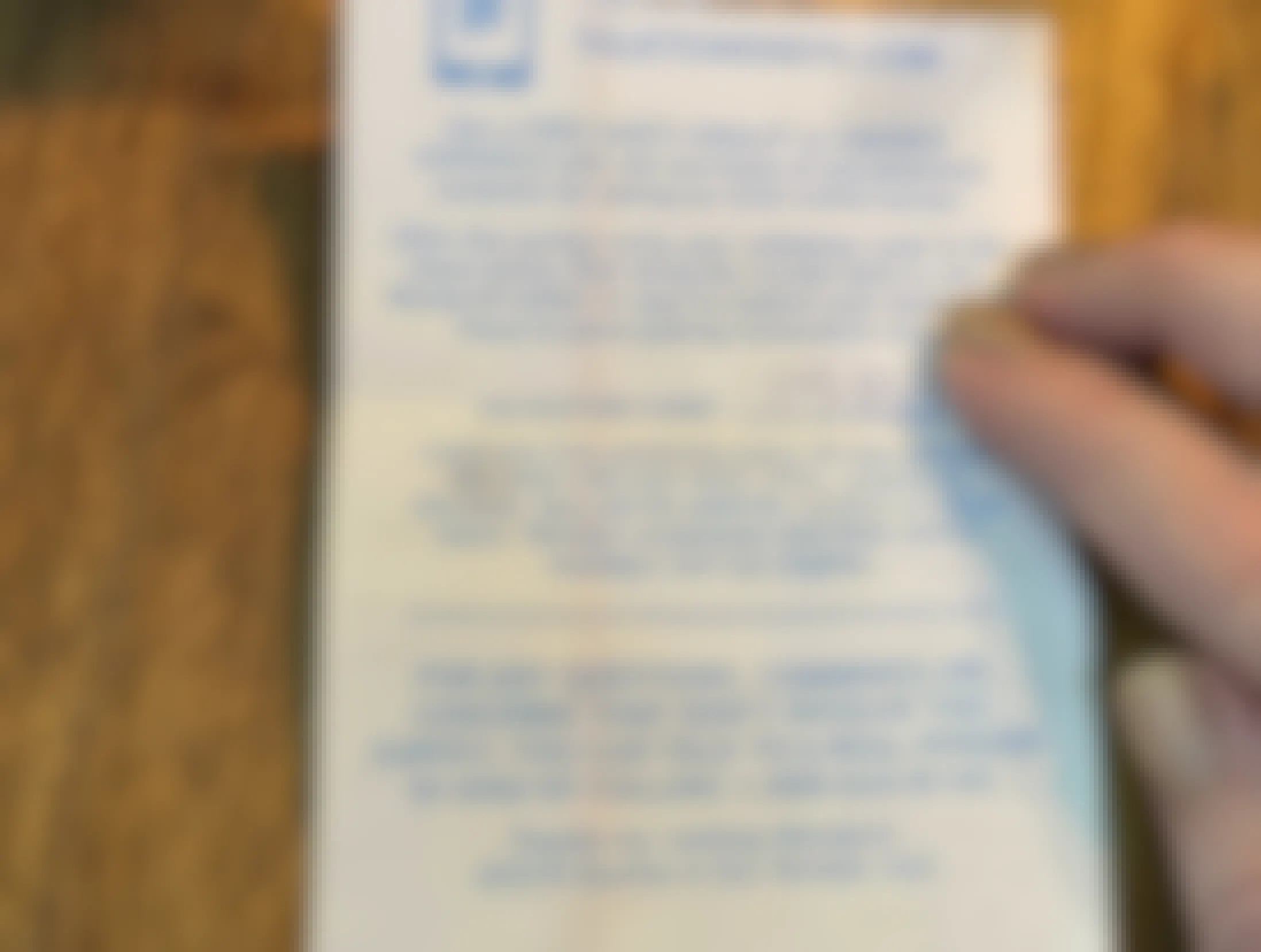 A Wendy's receipt on a table with a person's hand pointing out a handwritten validation code for a survey reward.
