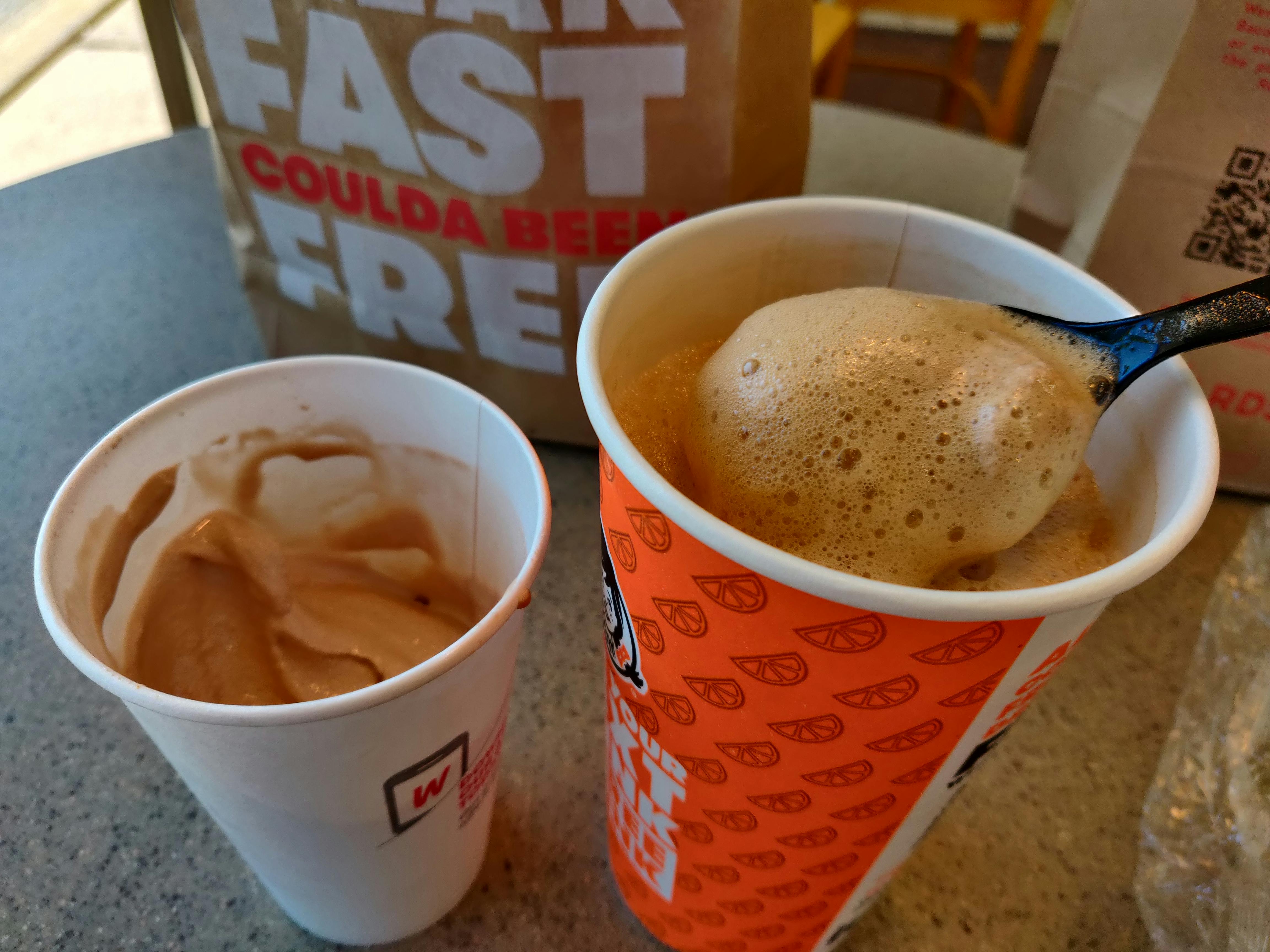 A Wendy's frosty and a Wendy's soda being mixed together with a spoon.