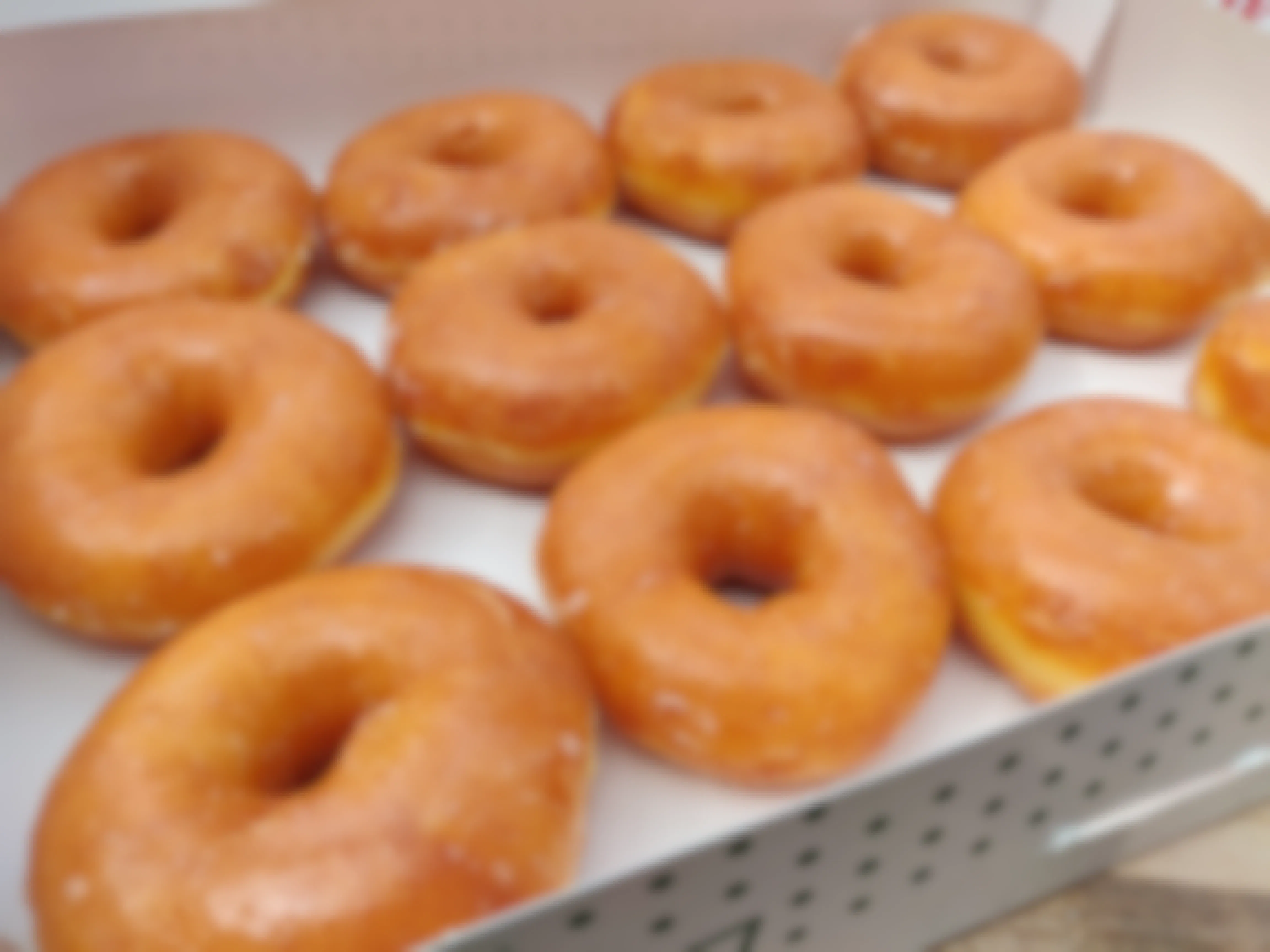 A dozen Krispy Kreme Original Glazed doughnuts in a box.