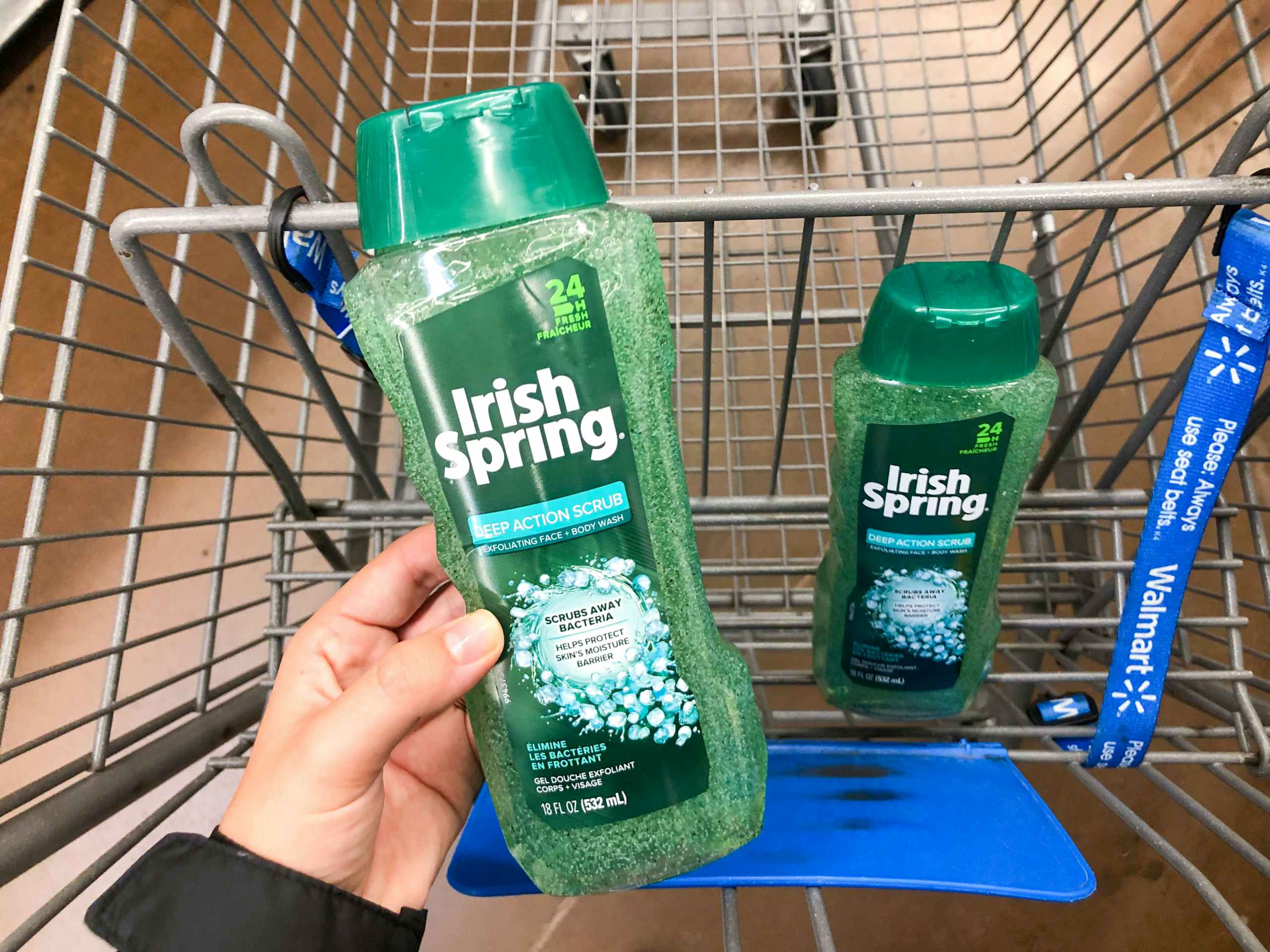 hand holding bottle of Irish Spring in front of shopping cart