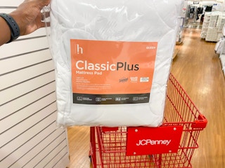 hand propping up mattress pad