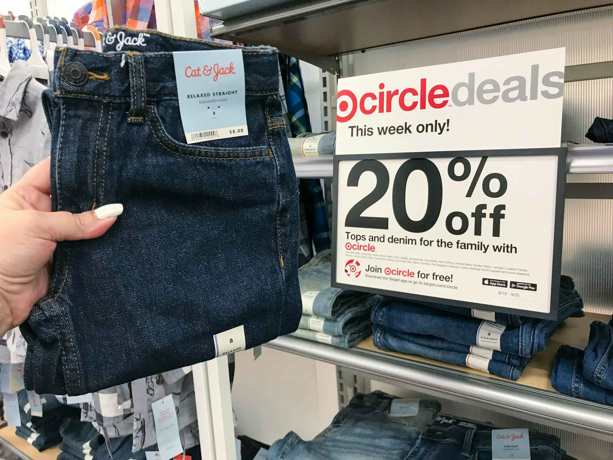 hand holding a pair of cat & jack boys' jeans in front of target circle sign