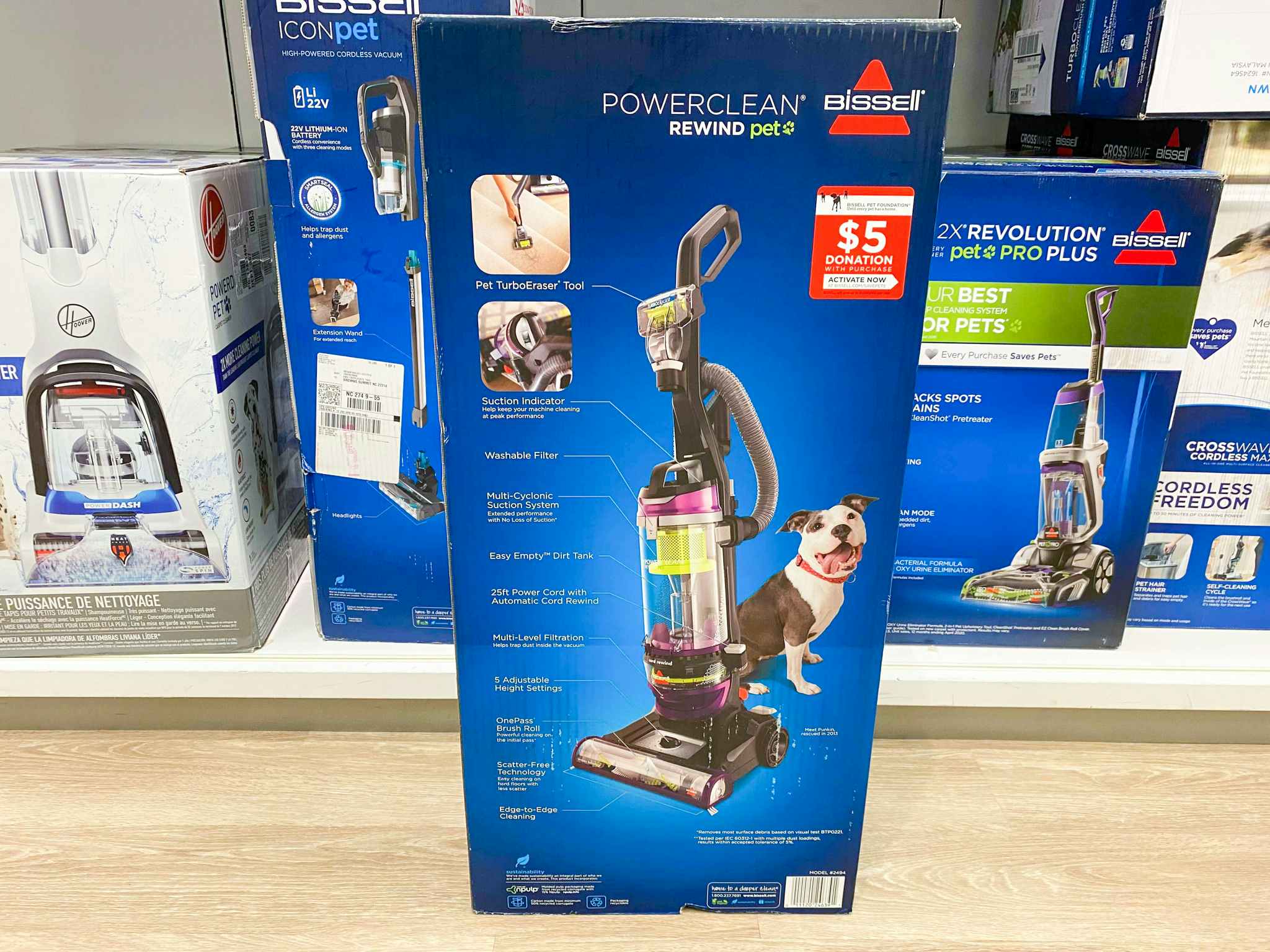 A Bissell vaccum cleaner box sitting on the floor in front of a shelf at Kohl's.