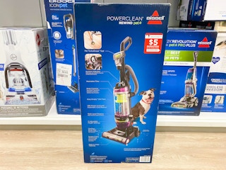 A Bissell vaccum cleaner box sitting on the floor in front of a shelf at Kohl's.