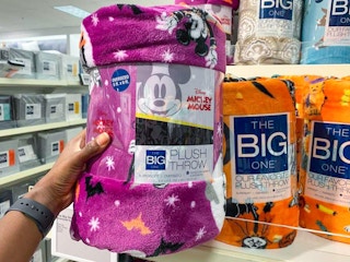 a Mickey Mouse throw held next to other throws in kohls
