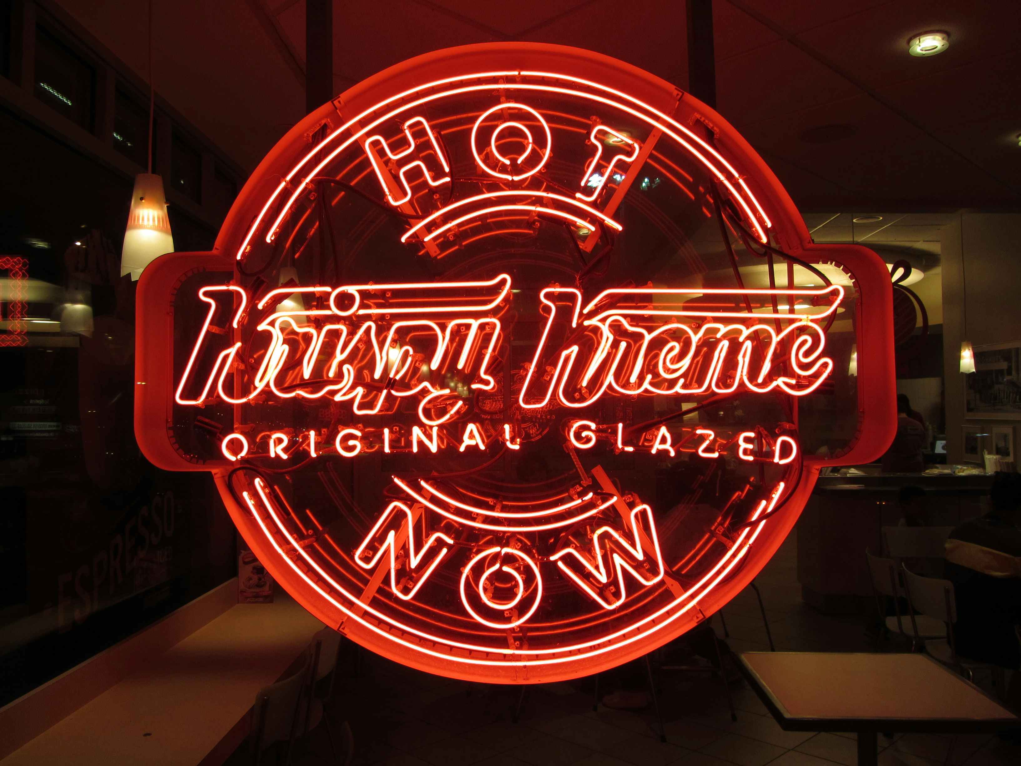 The Krispy Kreme Hot Now sign lit up red.