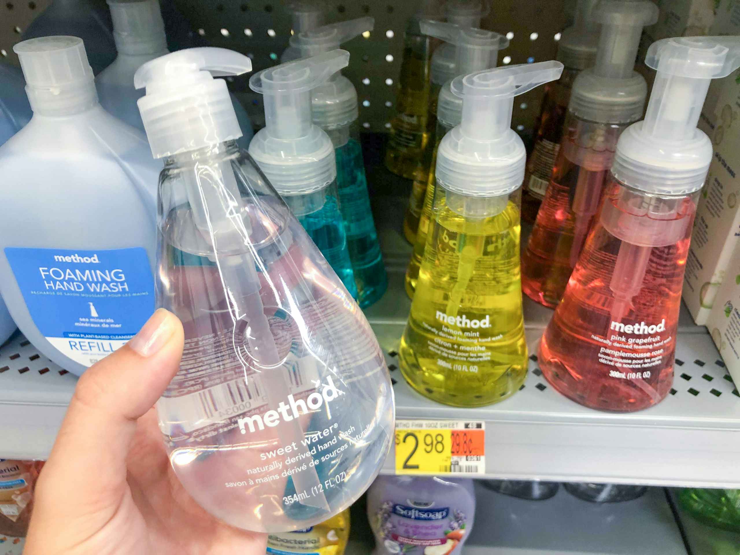 hand holding bottle of soap in front of aisle