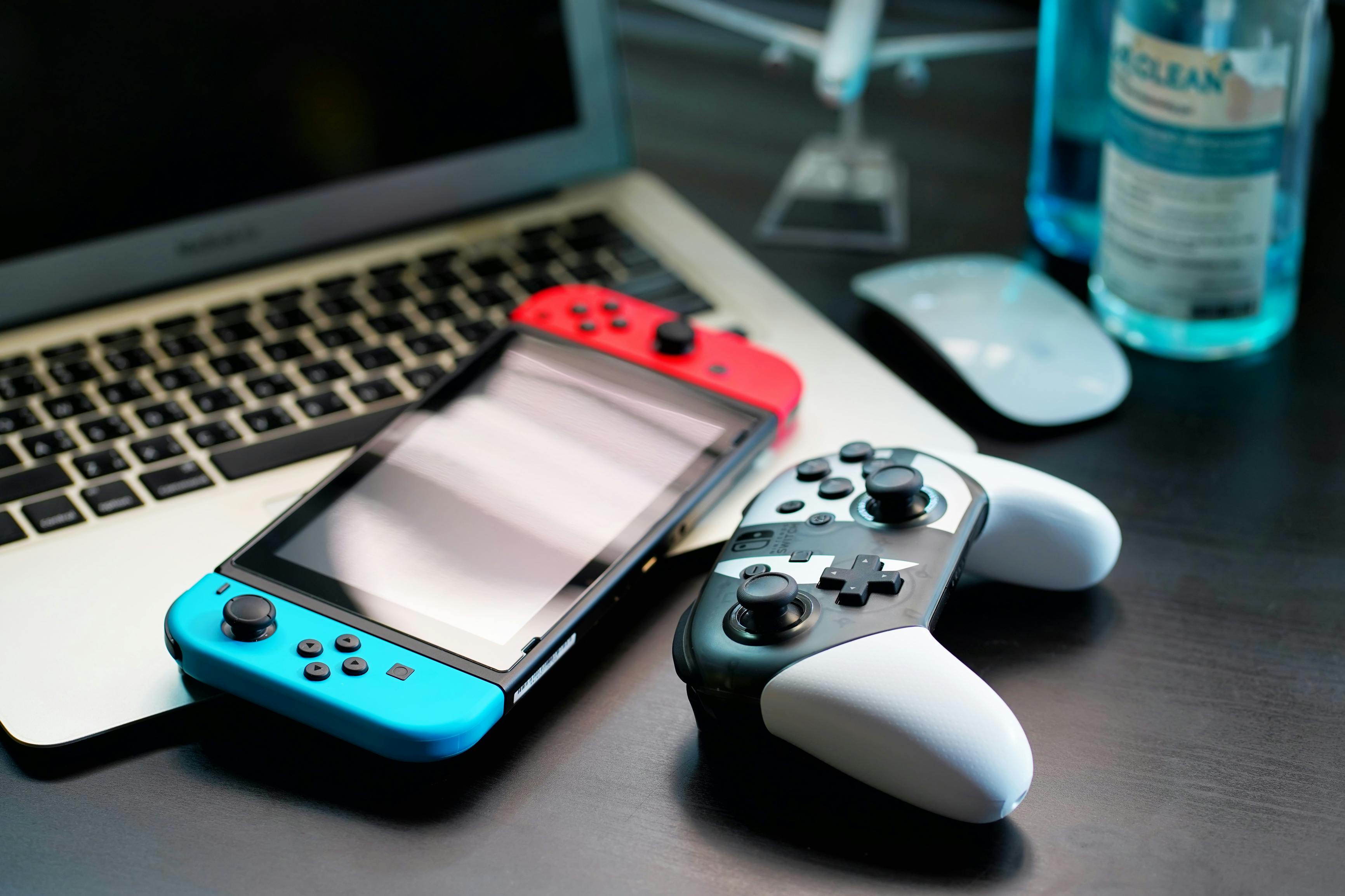 Nintendo Switch and controller on a table with laptop