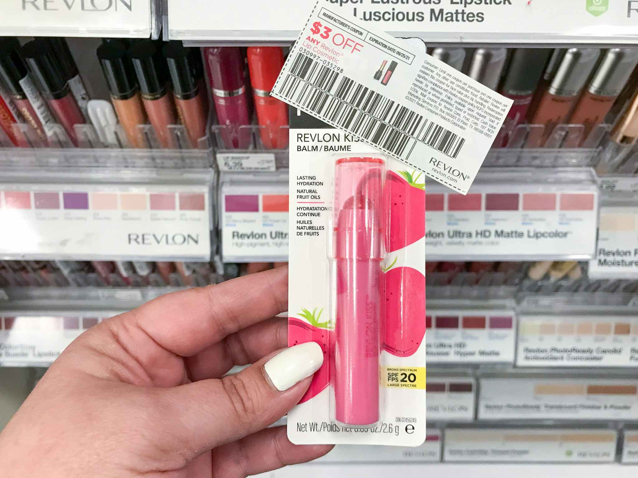 hand holding revlon kiss lip balm and coupon at target