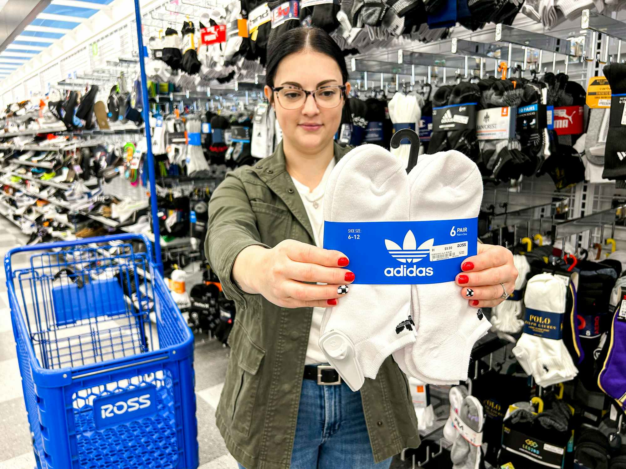 a person holding up adidas socks in a ross