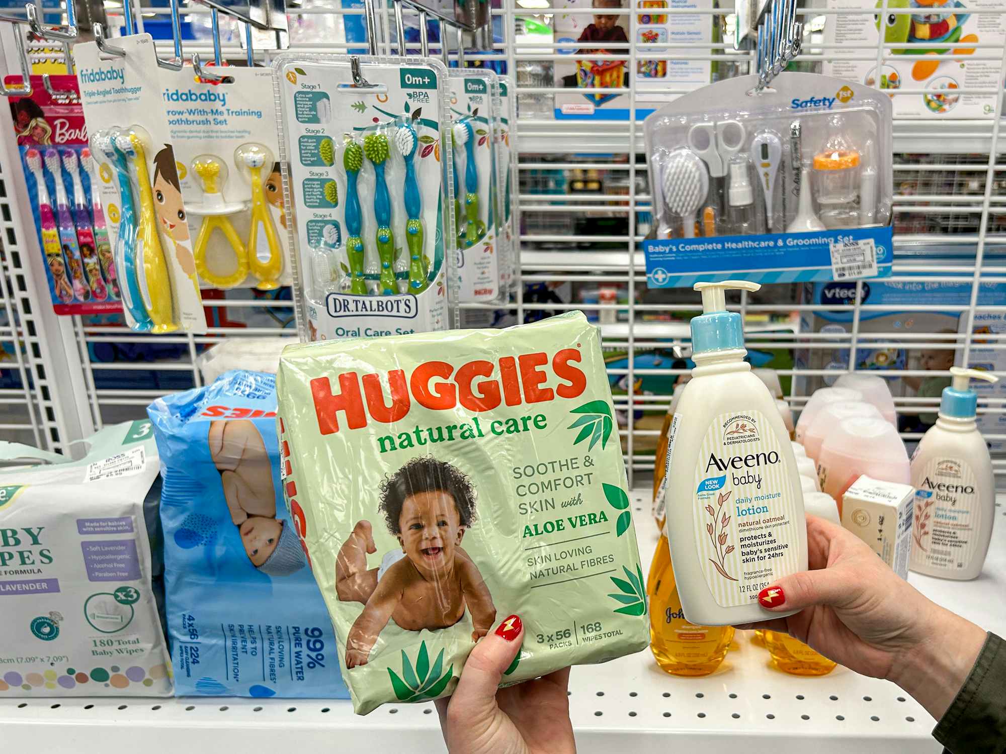 a person holding up huggie diapers and aveeno lotion