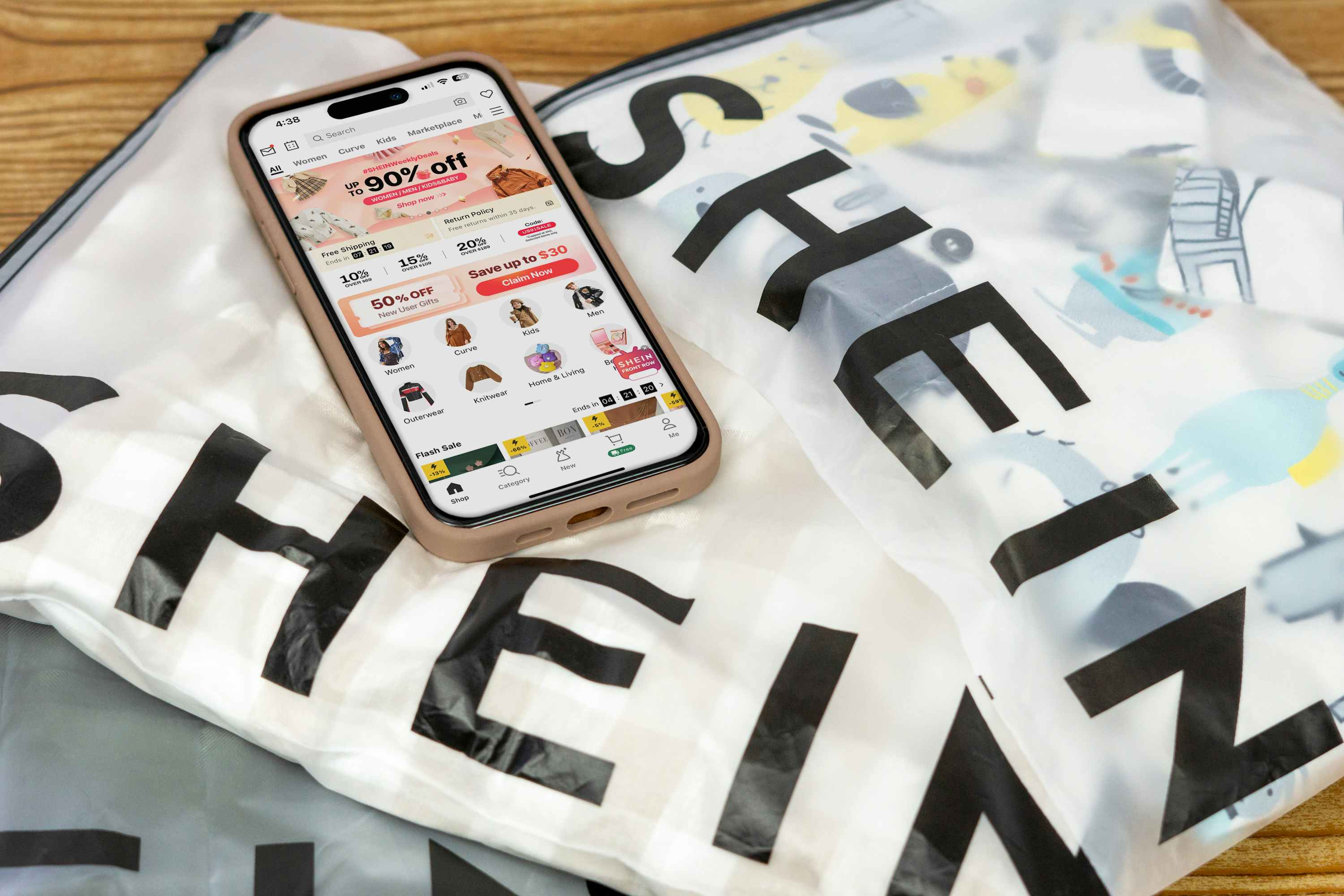a phone displaying the SHEIN app on top of some SHEIN bags