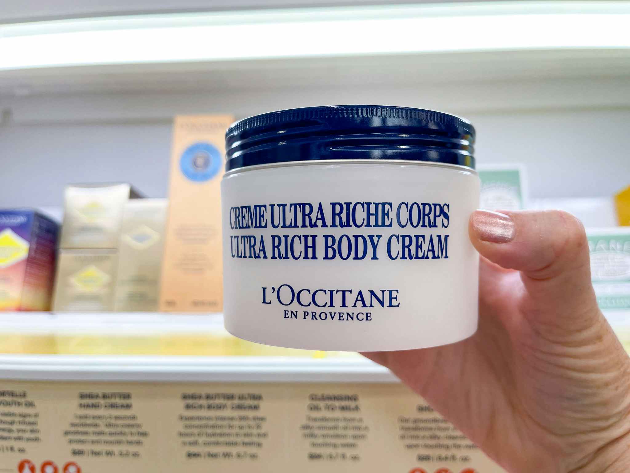 hand holding l'occitane body cream