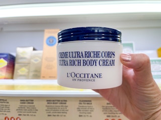 hand holding l'occitane body cream