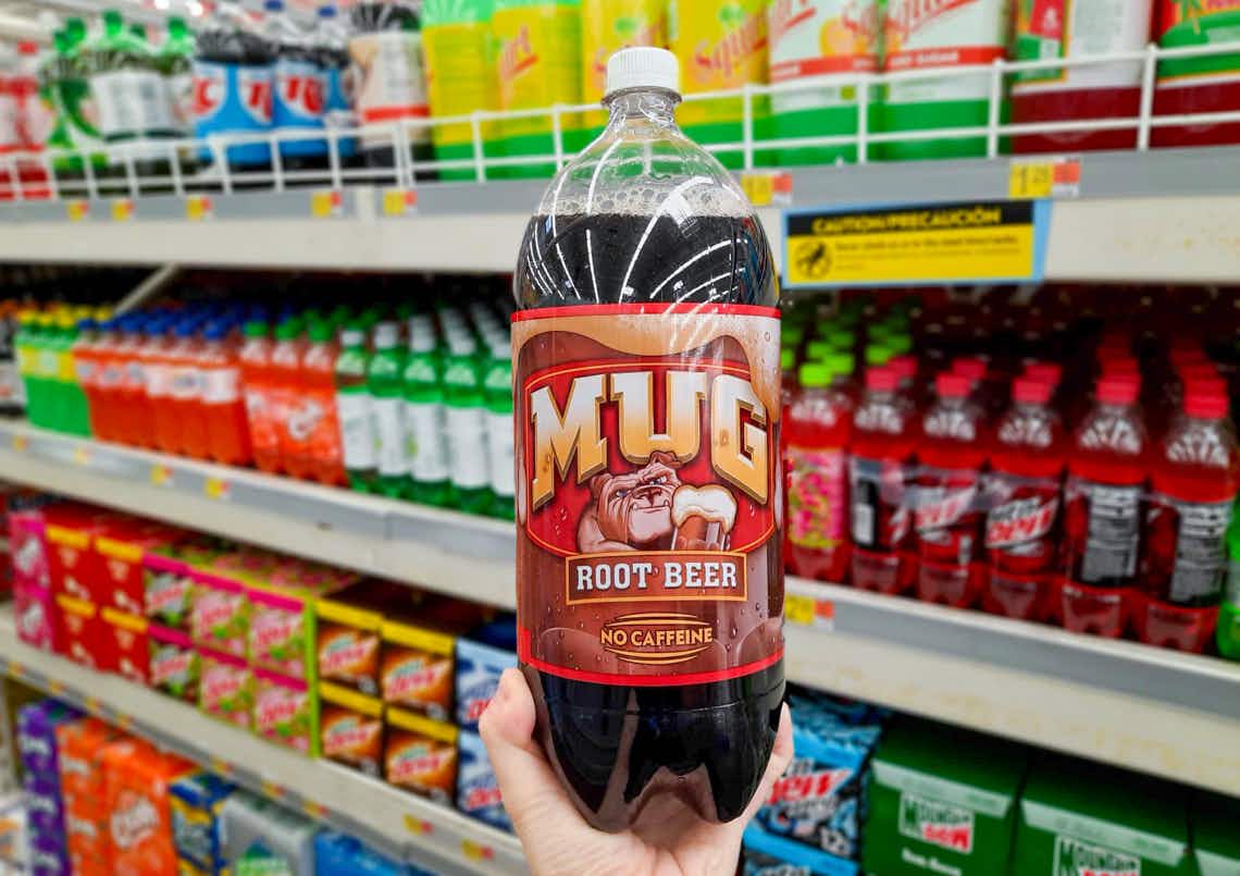 bottle of mug root beer held up in front of other sodas