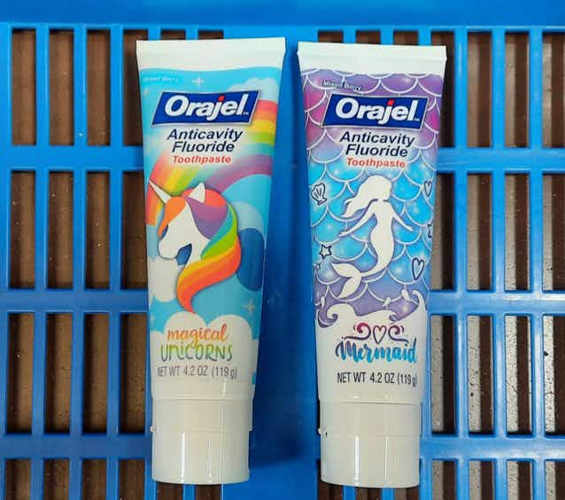 two tubes of orajel kids toothpaste in walmart basket