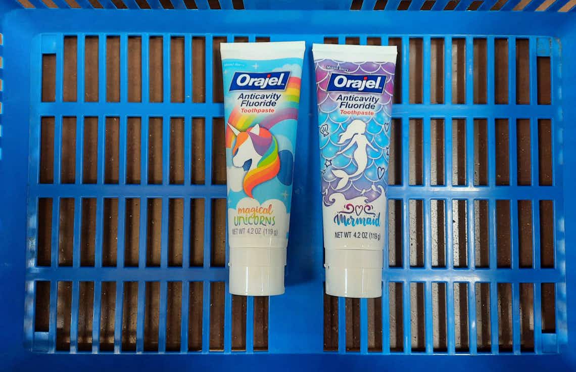 two tubes of orajel kids toothpaste in walmart basket