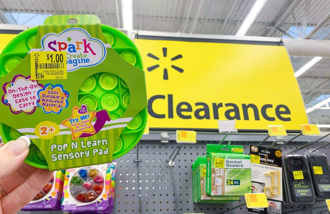 spark create imagine pop n learn sensory pad held up in front of walmart clearance sign