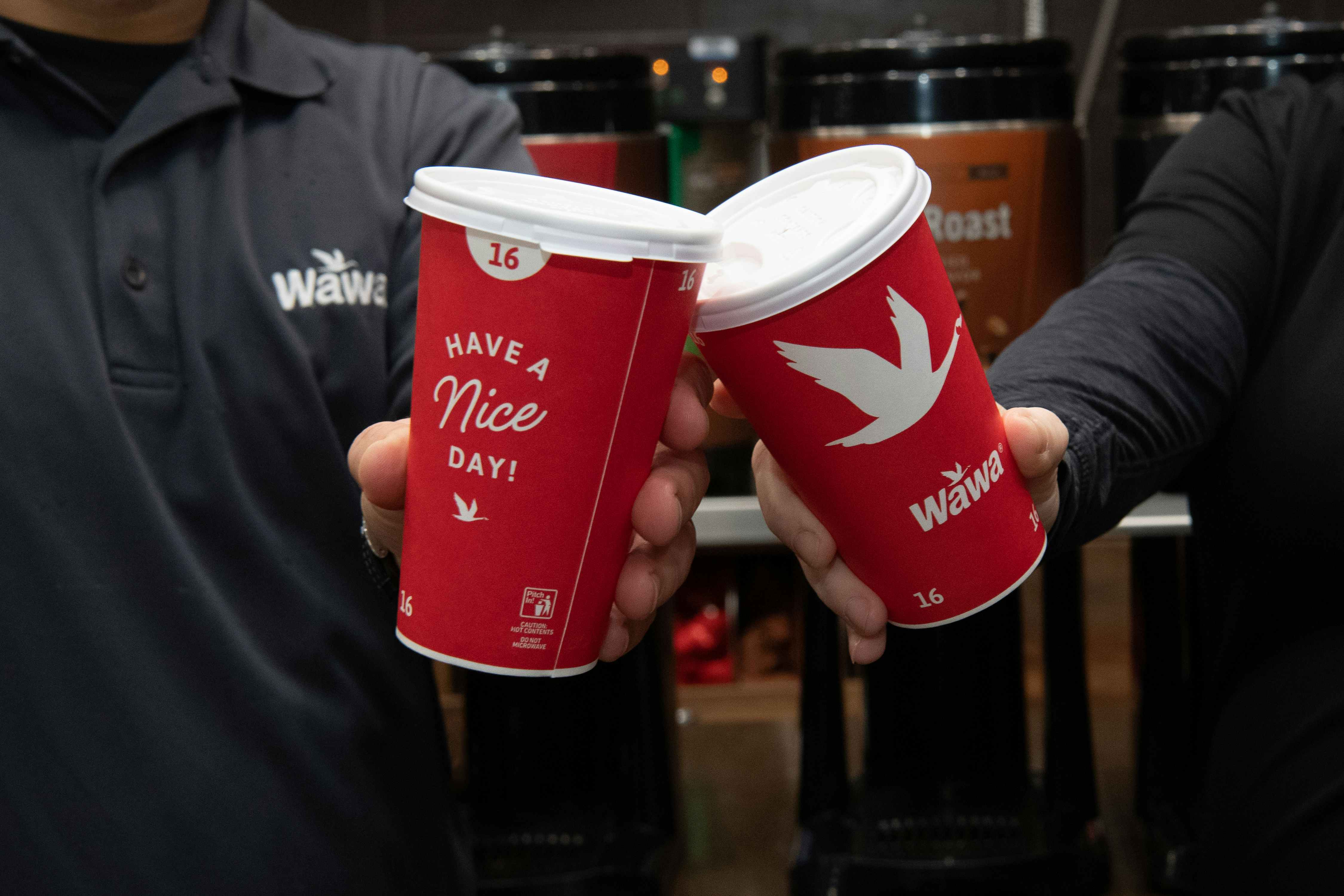 Wawa employees holding red coffee cups