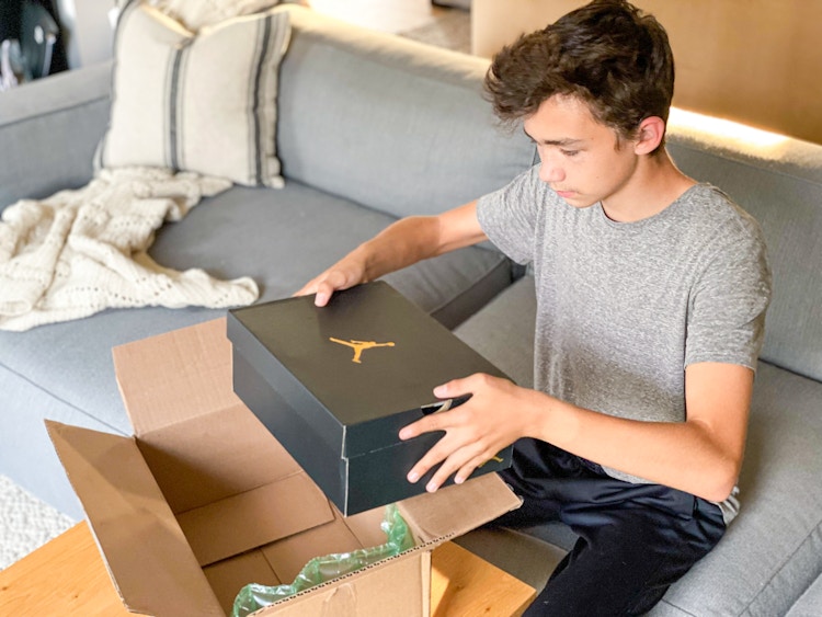 boy pulling a shoe box out of a box