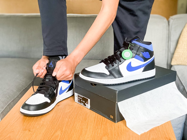 someone tying nike sneakers on a table