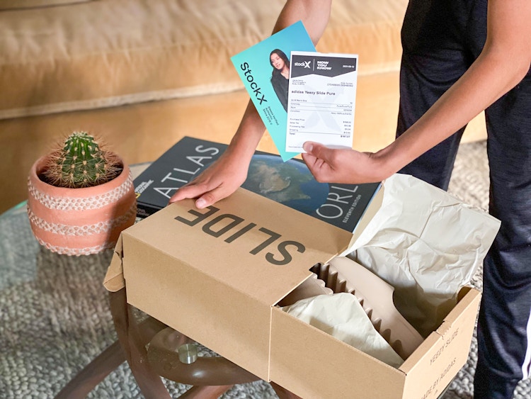 someone pulling out stockx card from shoe box