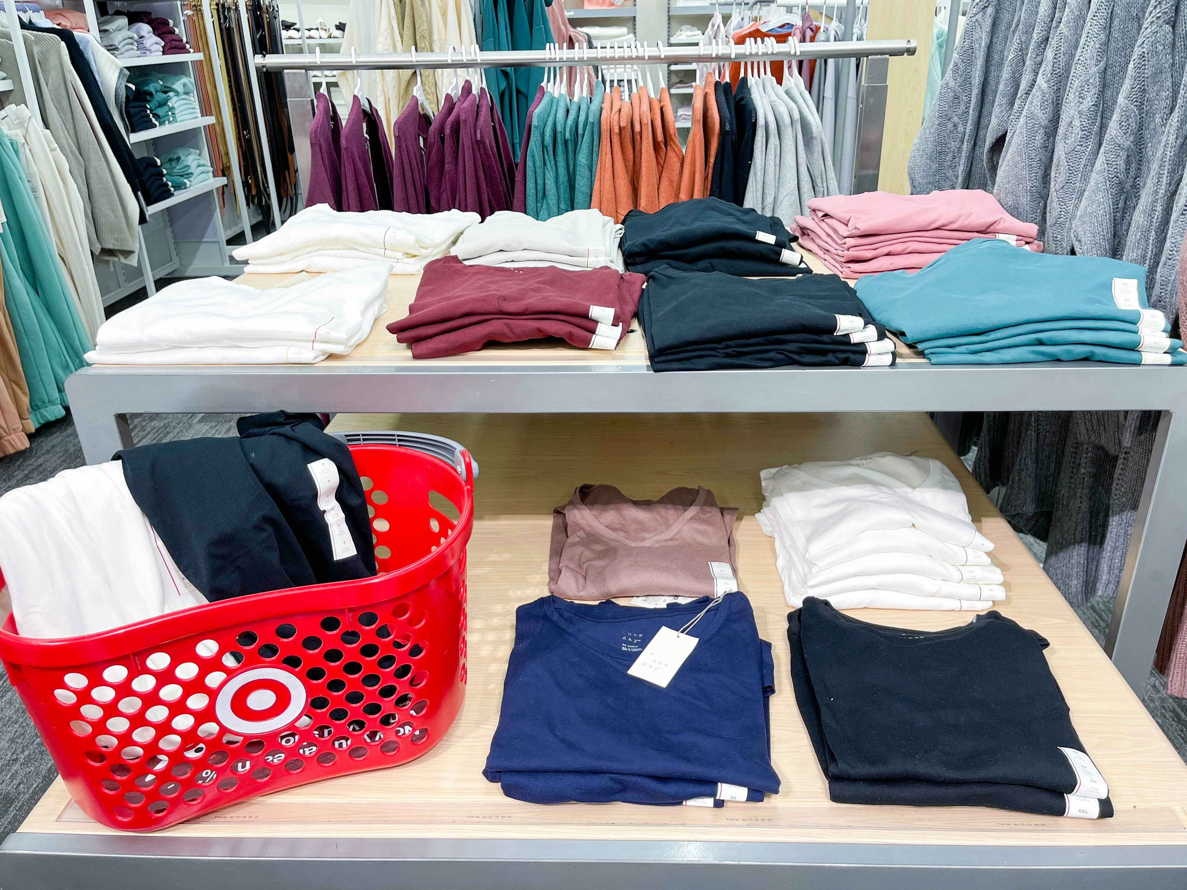 tee shirts on display shelves and in target basket