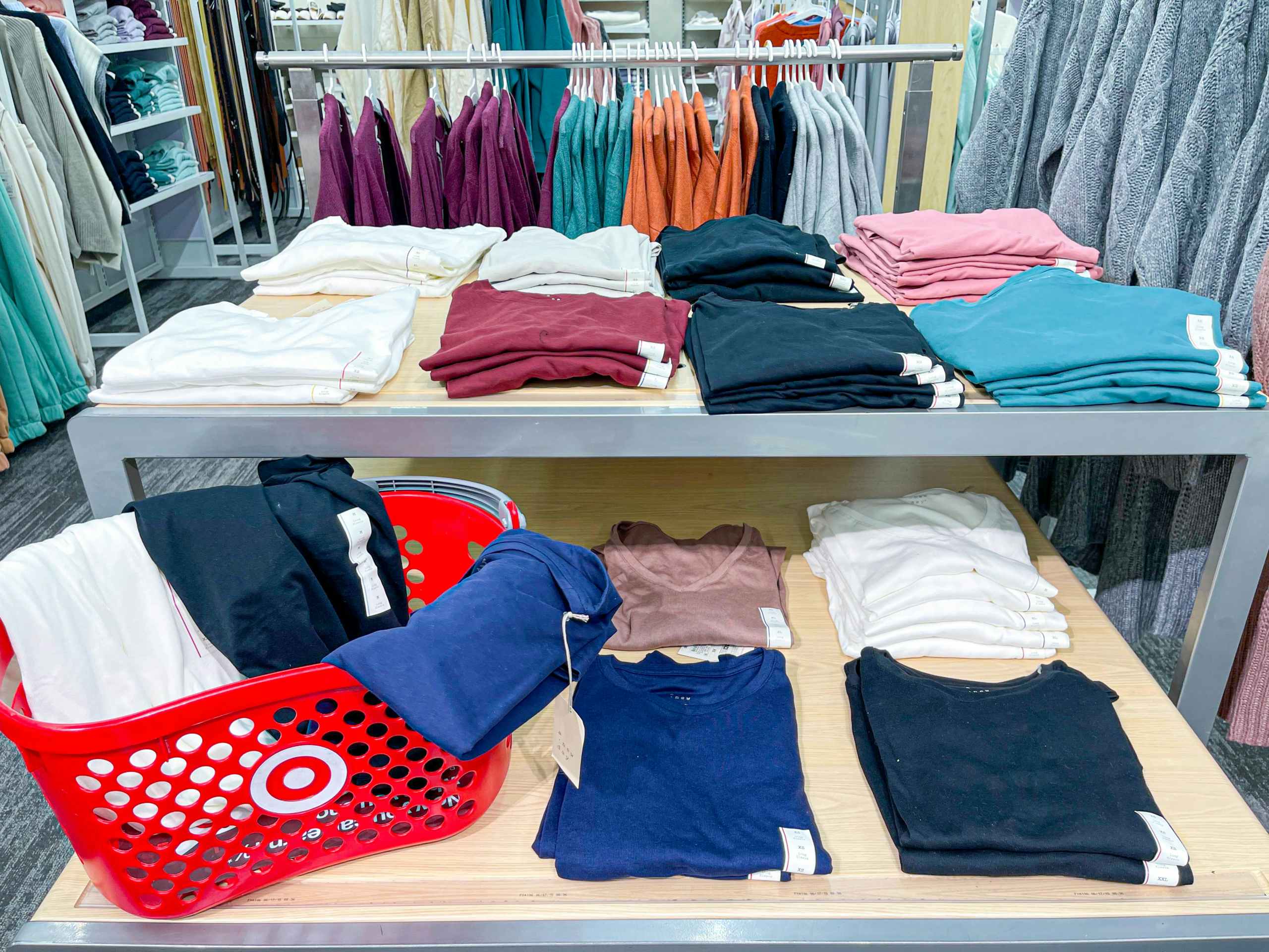 tee shirts on display shelves and in target basket