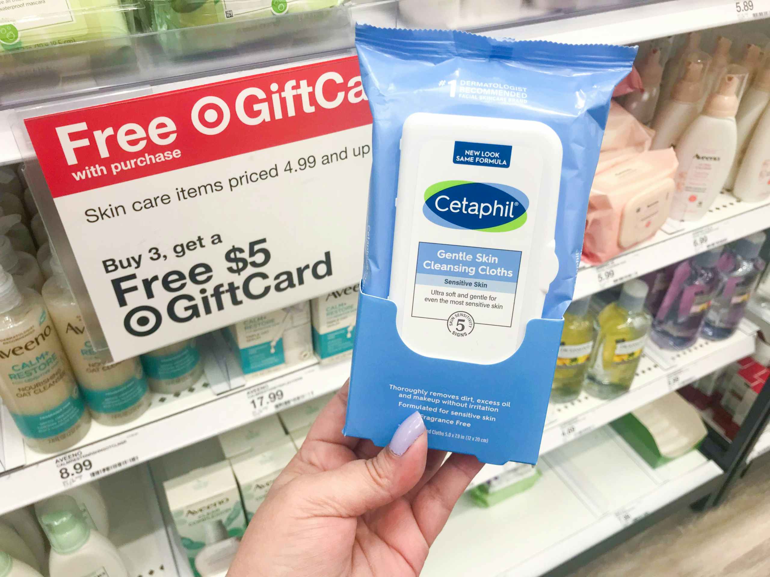 hand holding cetaphil wipes in front of Target promotion sign