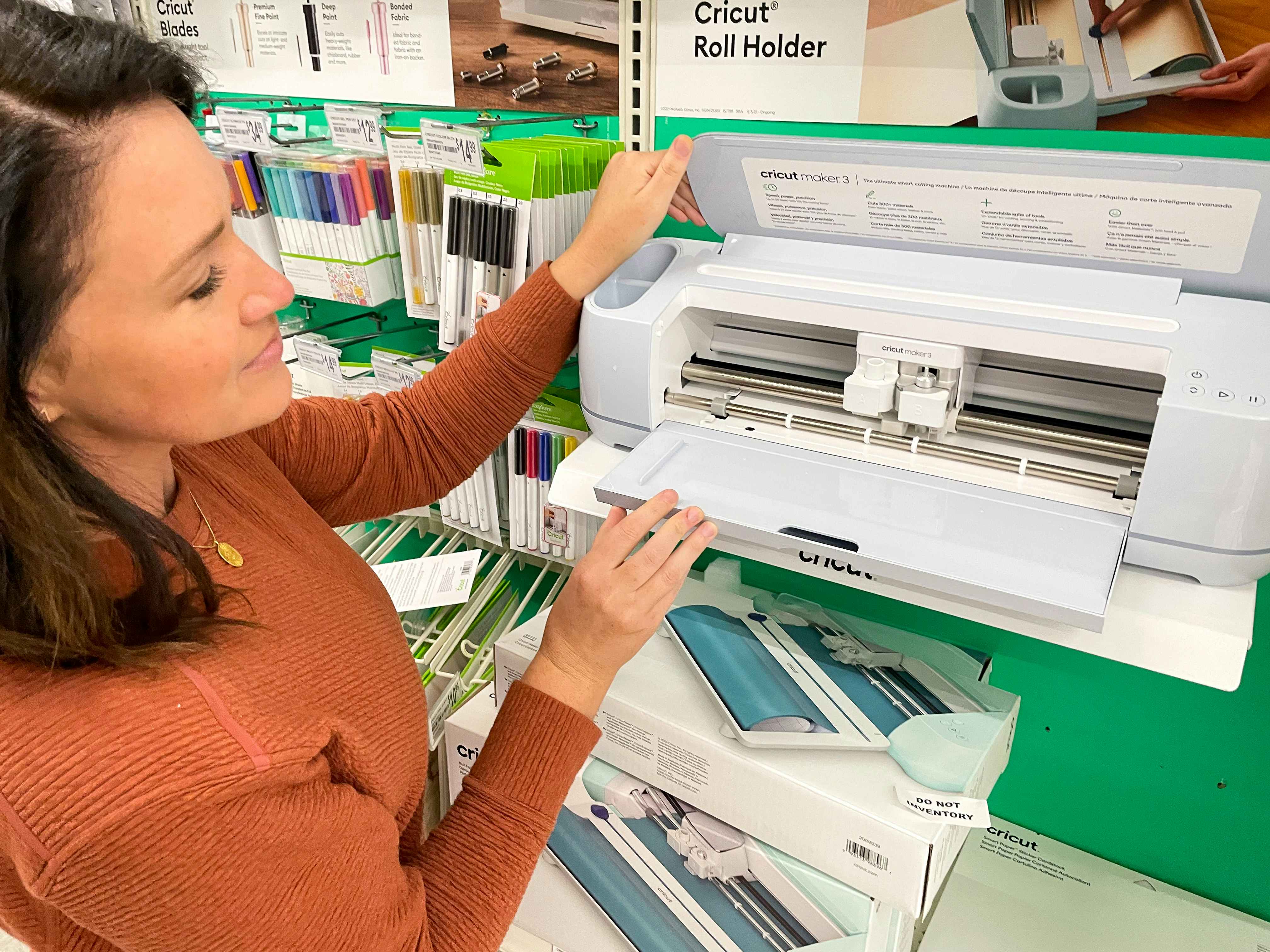 A person looking at the Cricut Maker 3 on display inside a craft store