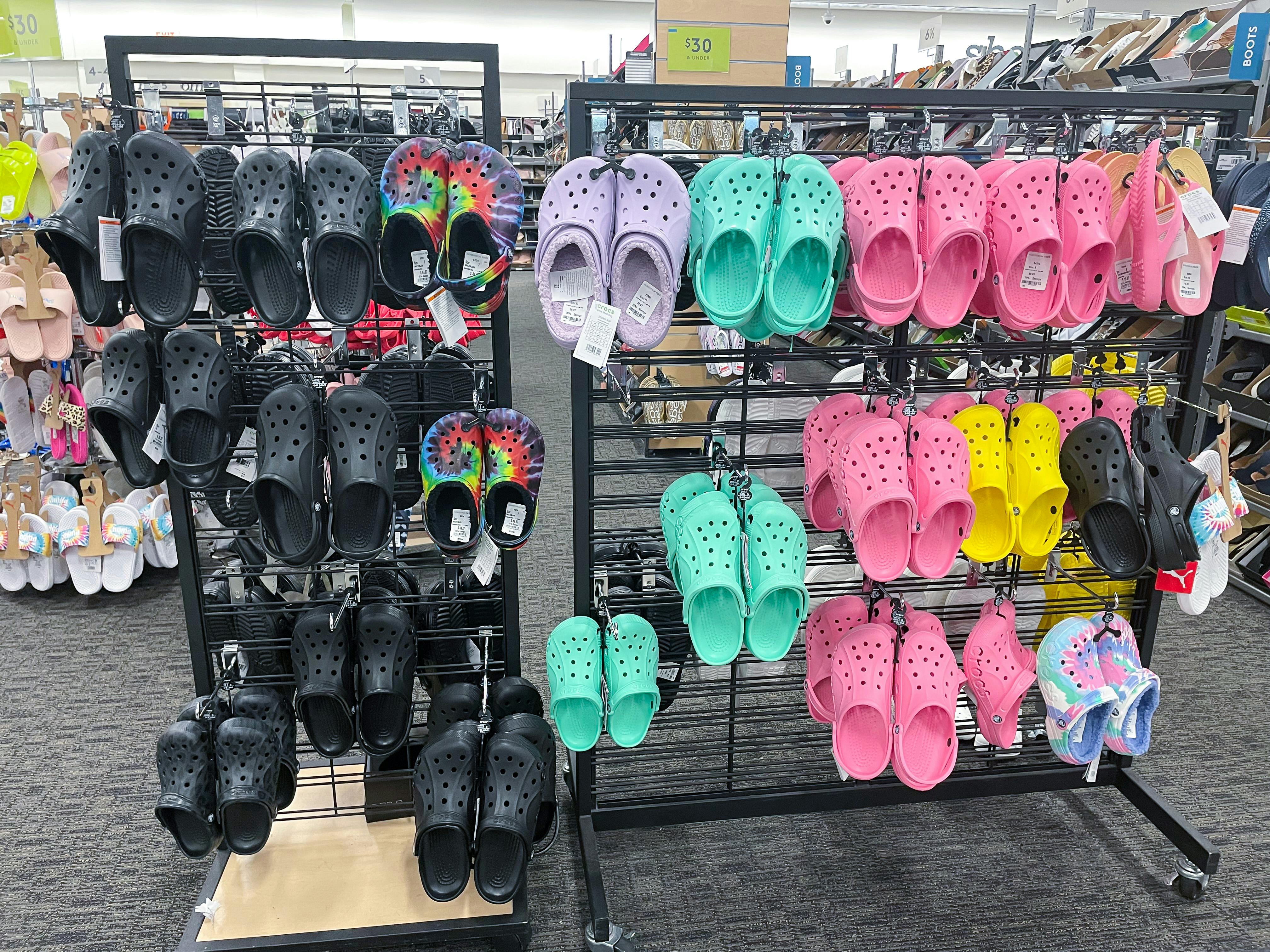 A display of hanging Crocs classic clogs at a shoe store.