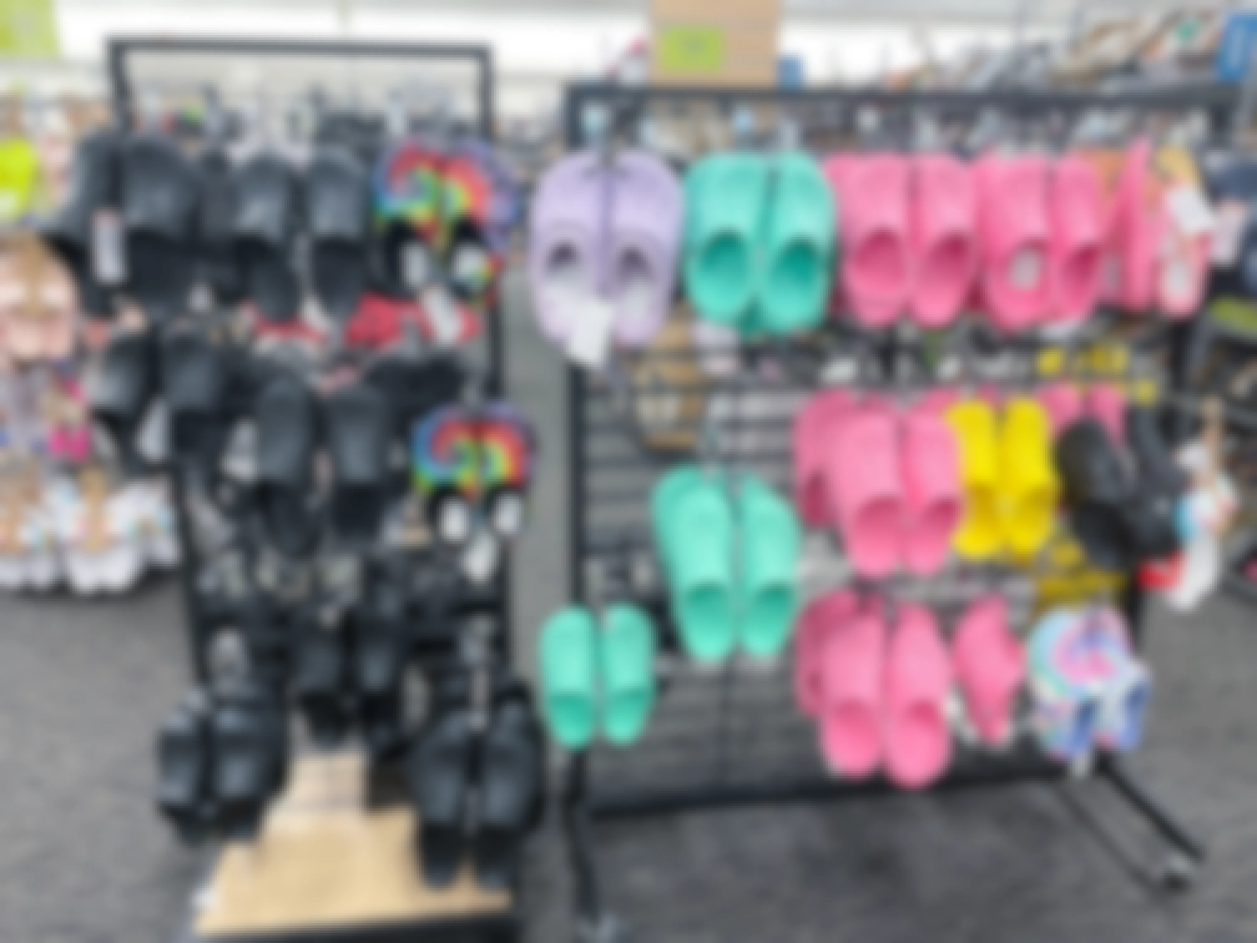 A display of hanging Crocs classic clogs at a shoe store.