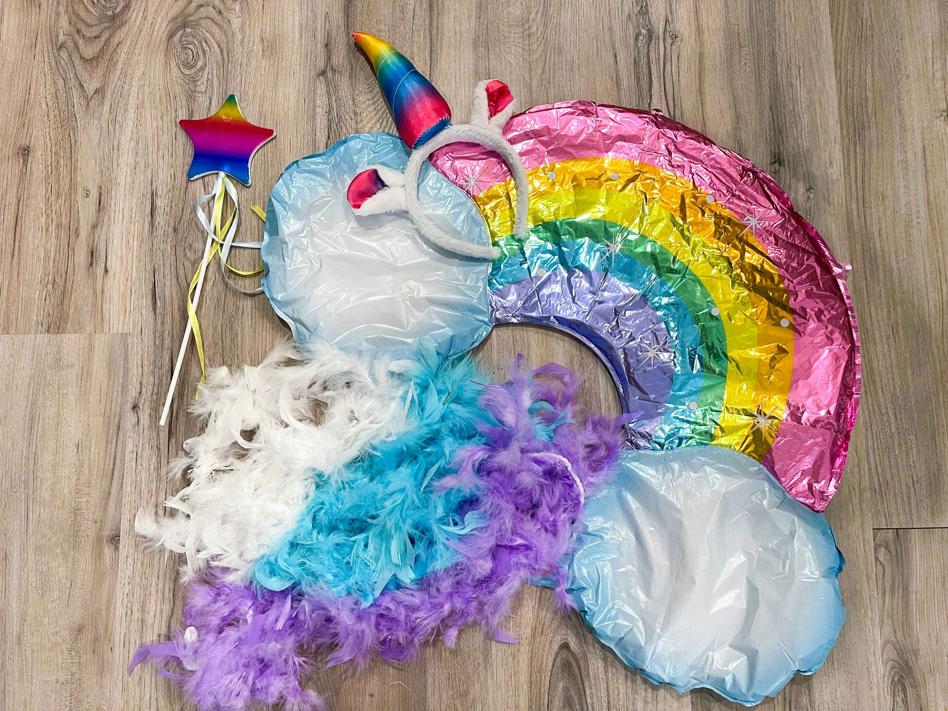 Materials for a DIY unicorn rainbow costume piled together on the floor.