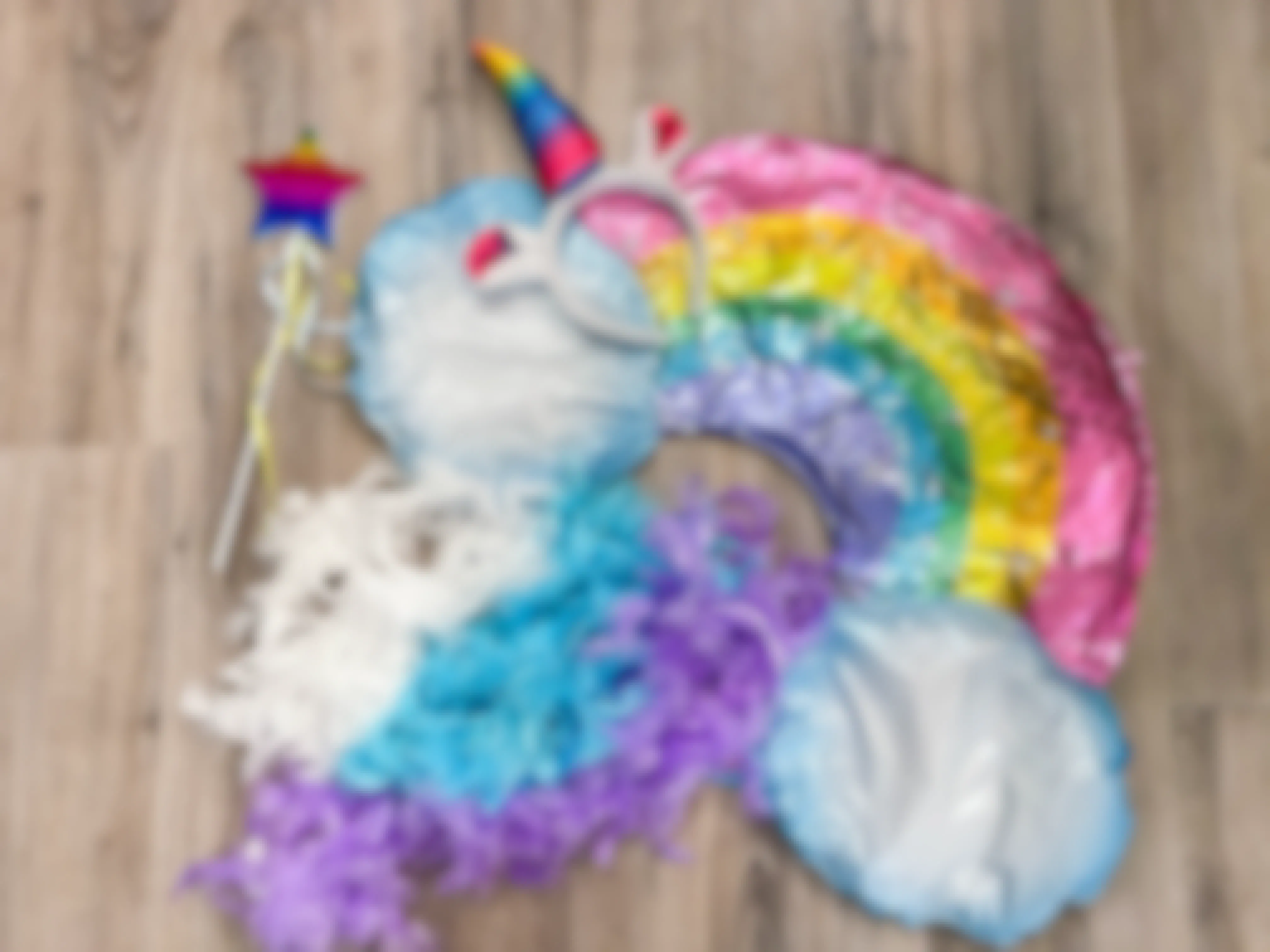 Materials for a DIY unicorn rainbow costume piled together on the floor.