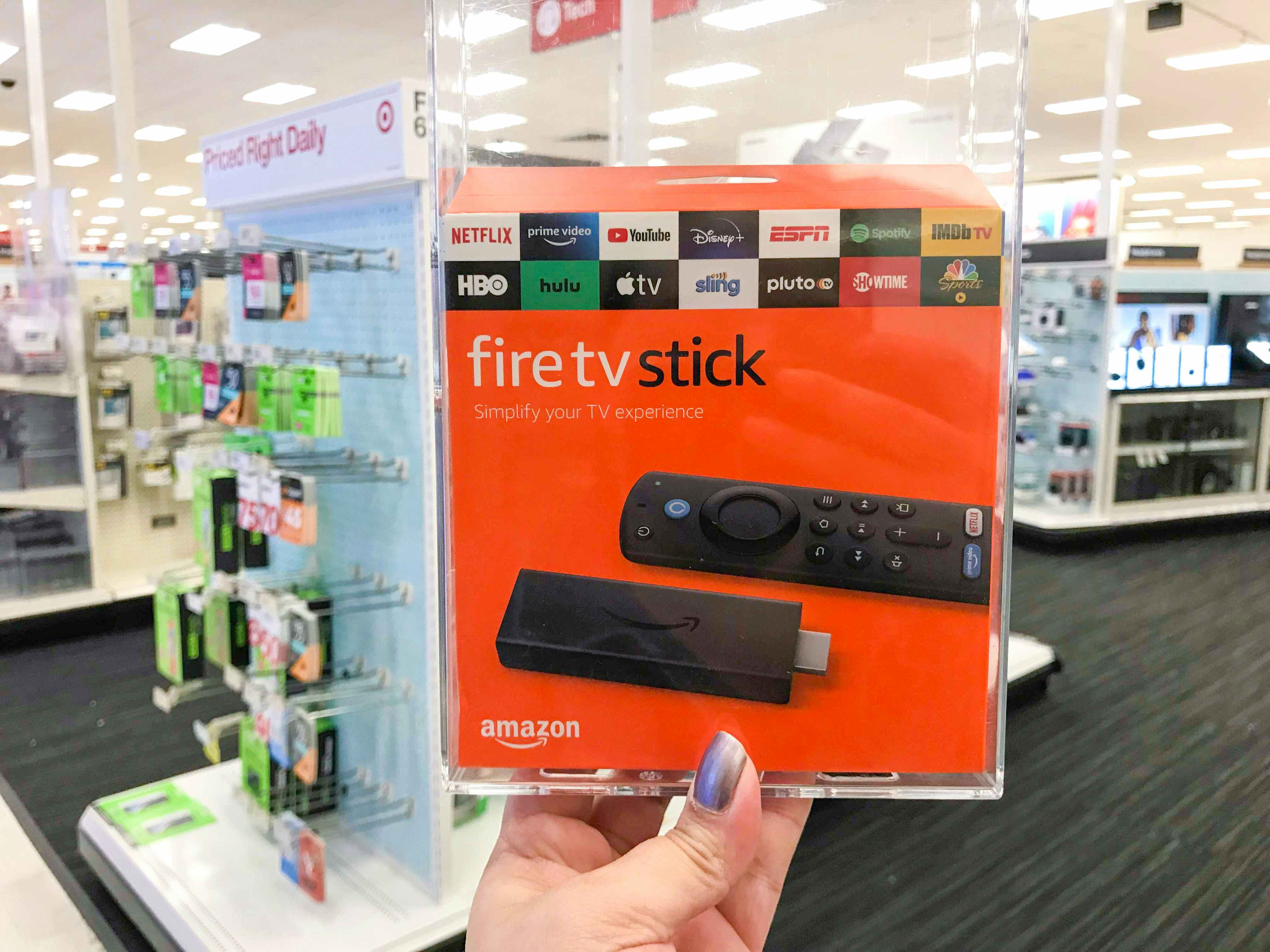 hand holding up the Amazon Fire Stick TV box in Target electronics section