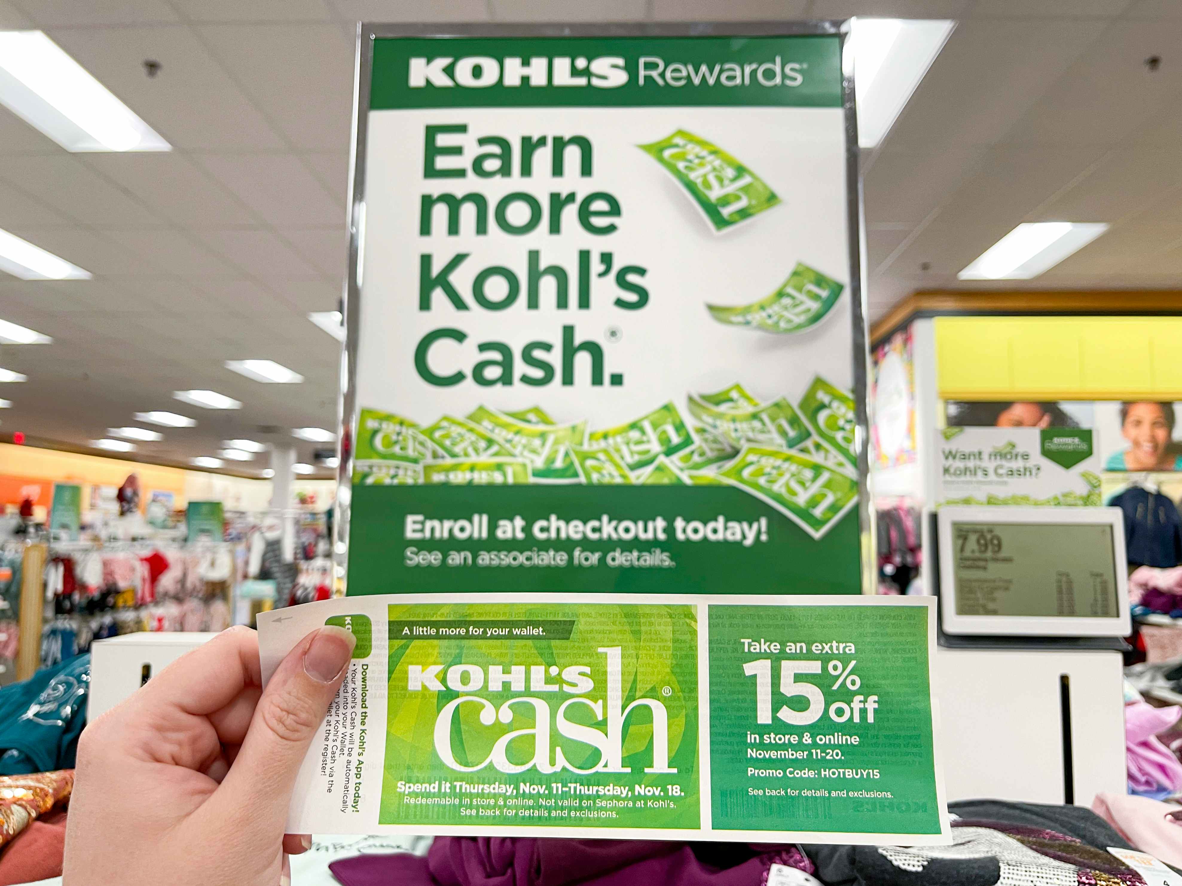A person holding Kohl's cash near a Kohl's cash sign