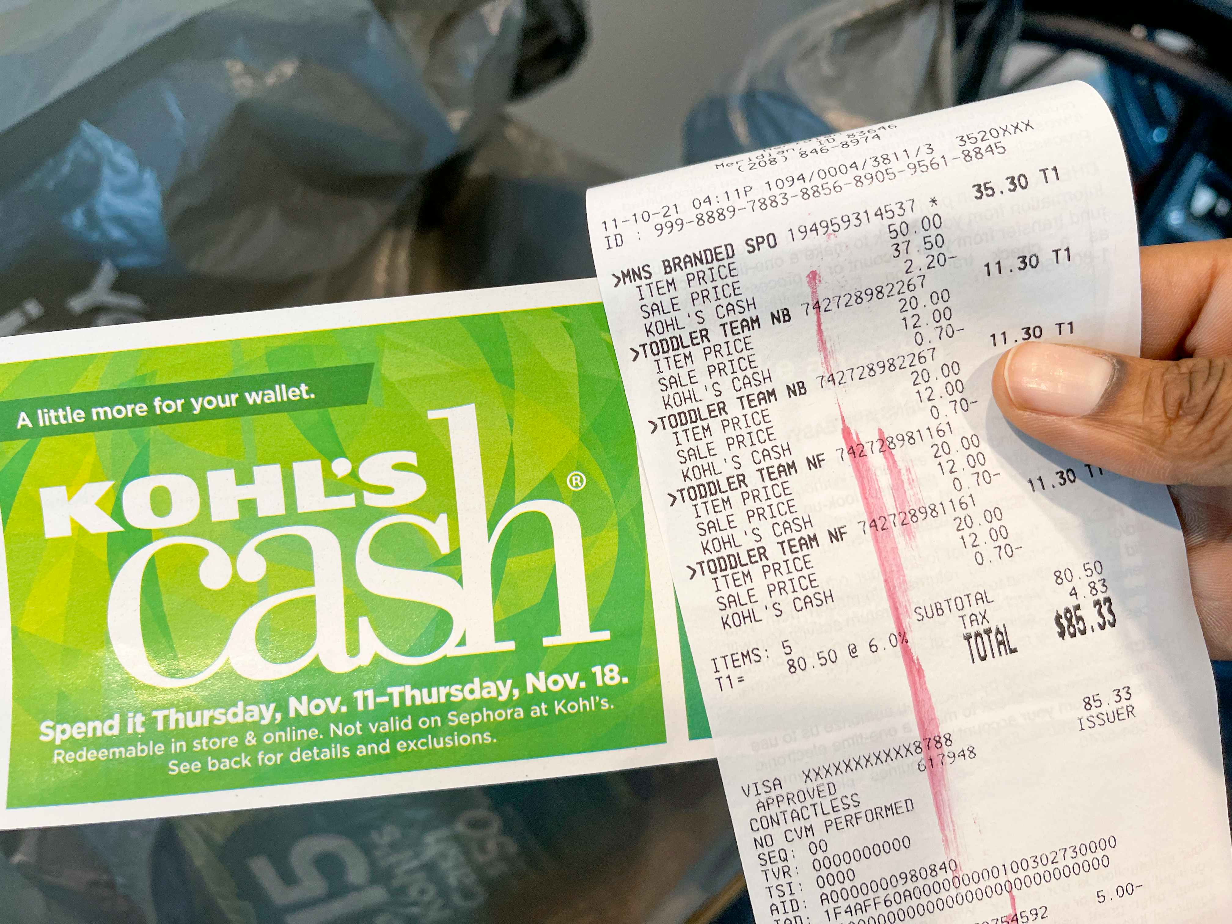 A person holding Kohl's cash and a receipt