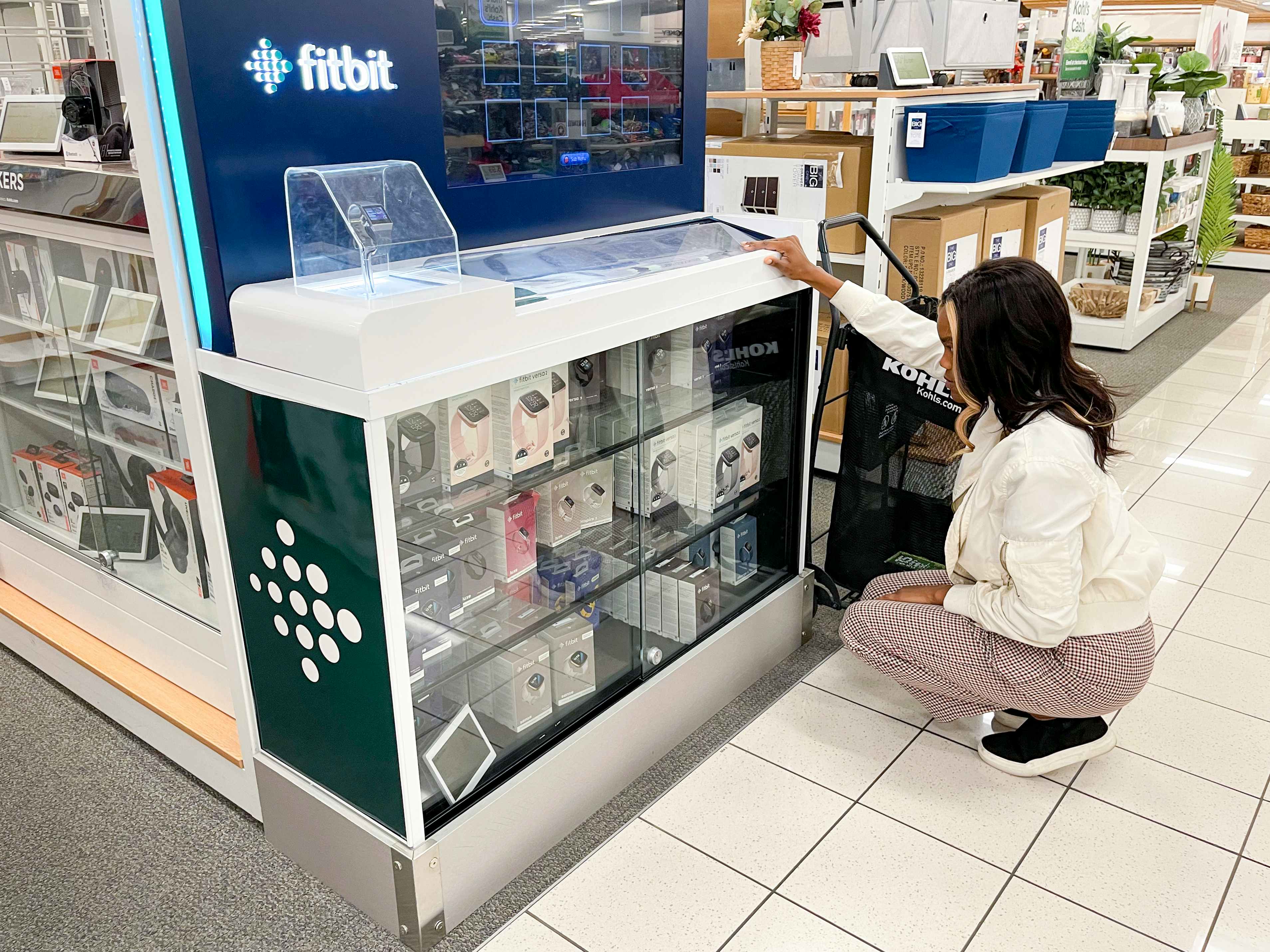 A woman looking at Fitbit watches in a display case