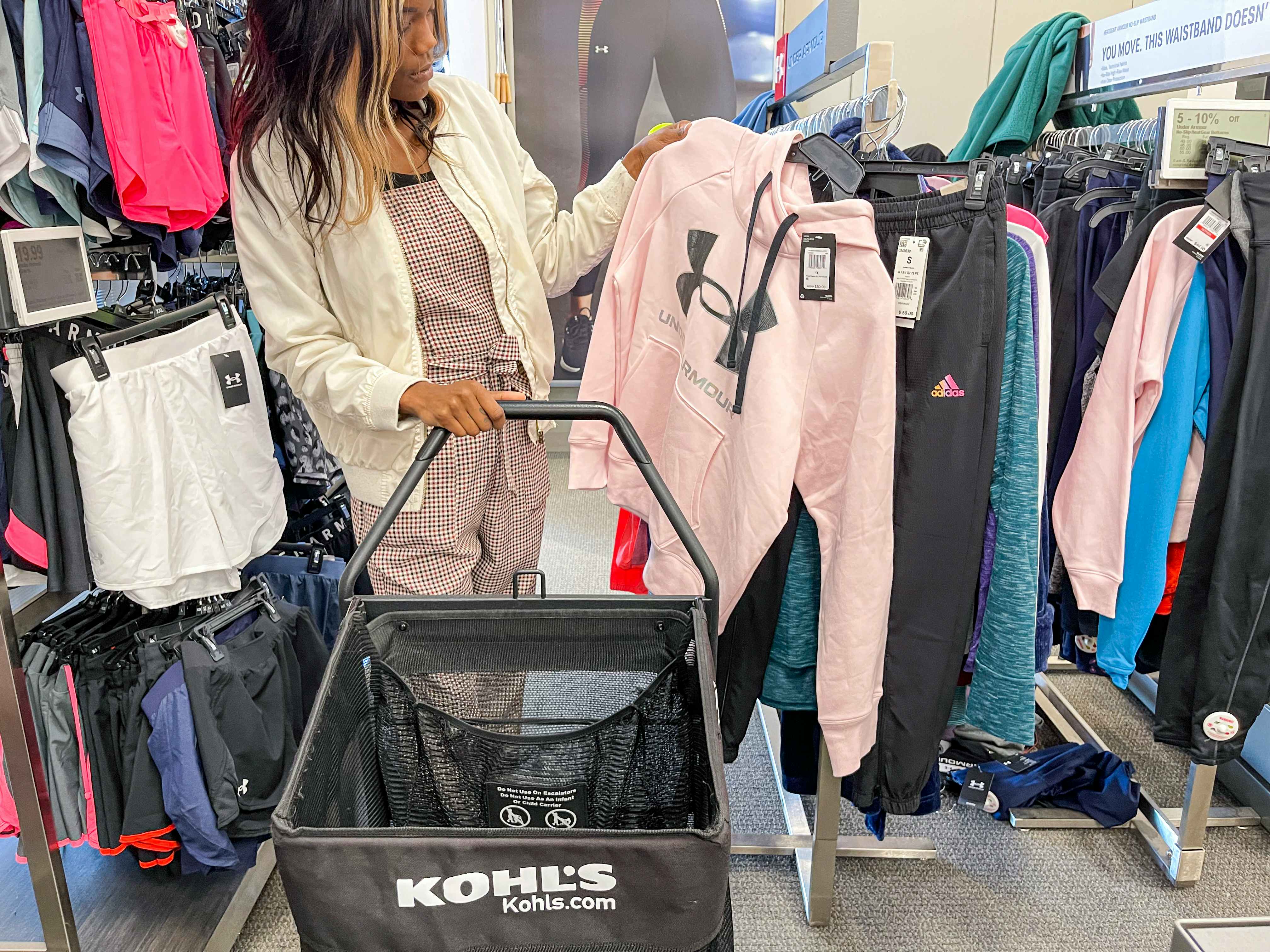 A woman shopping for under armour apparel at Kohls