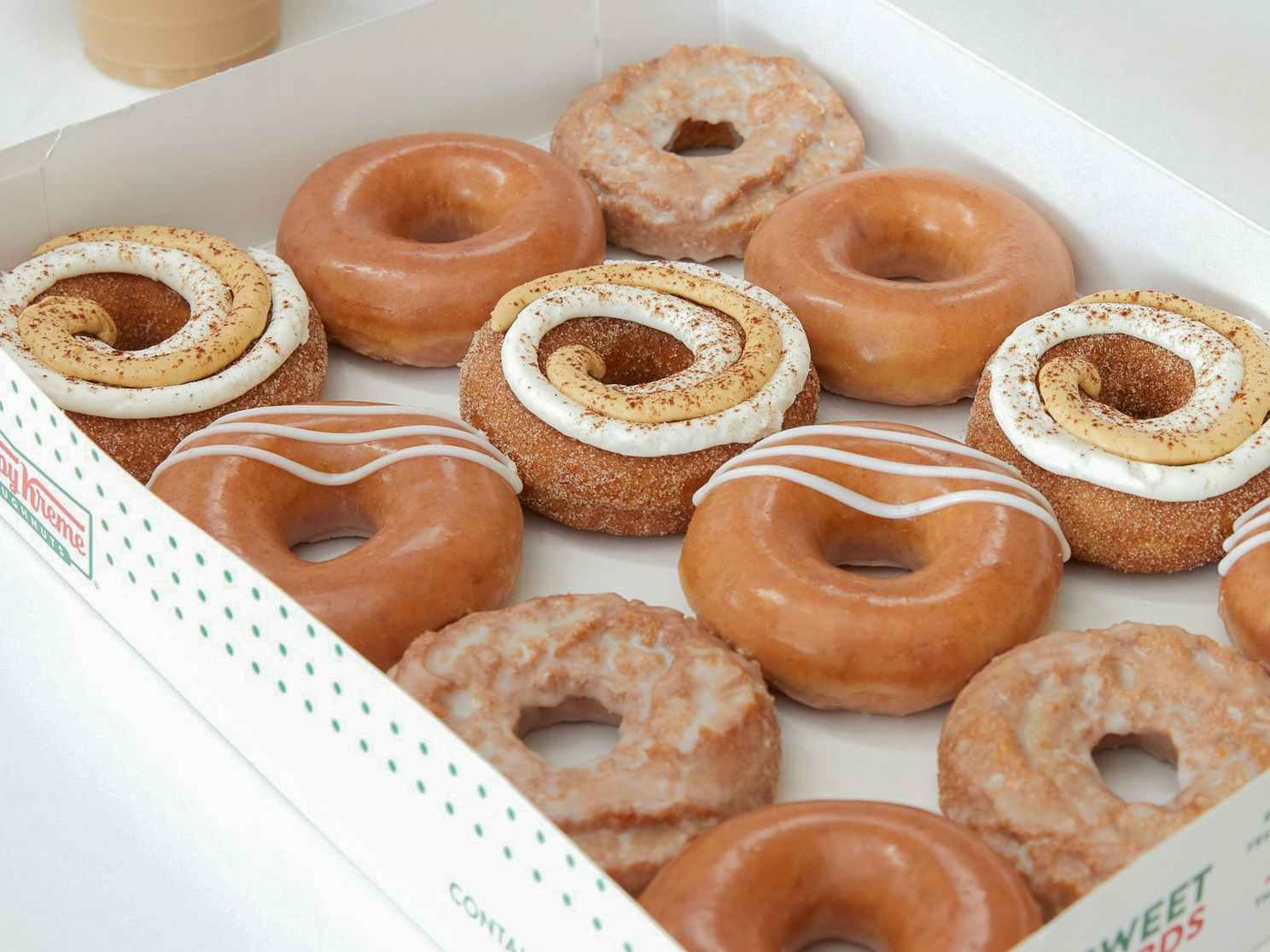 A close up on a dozen Krispy Kreme pumpkin spice flavored doughnuts.