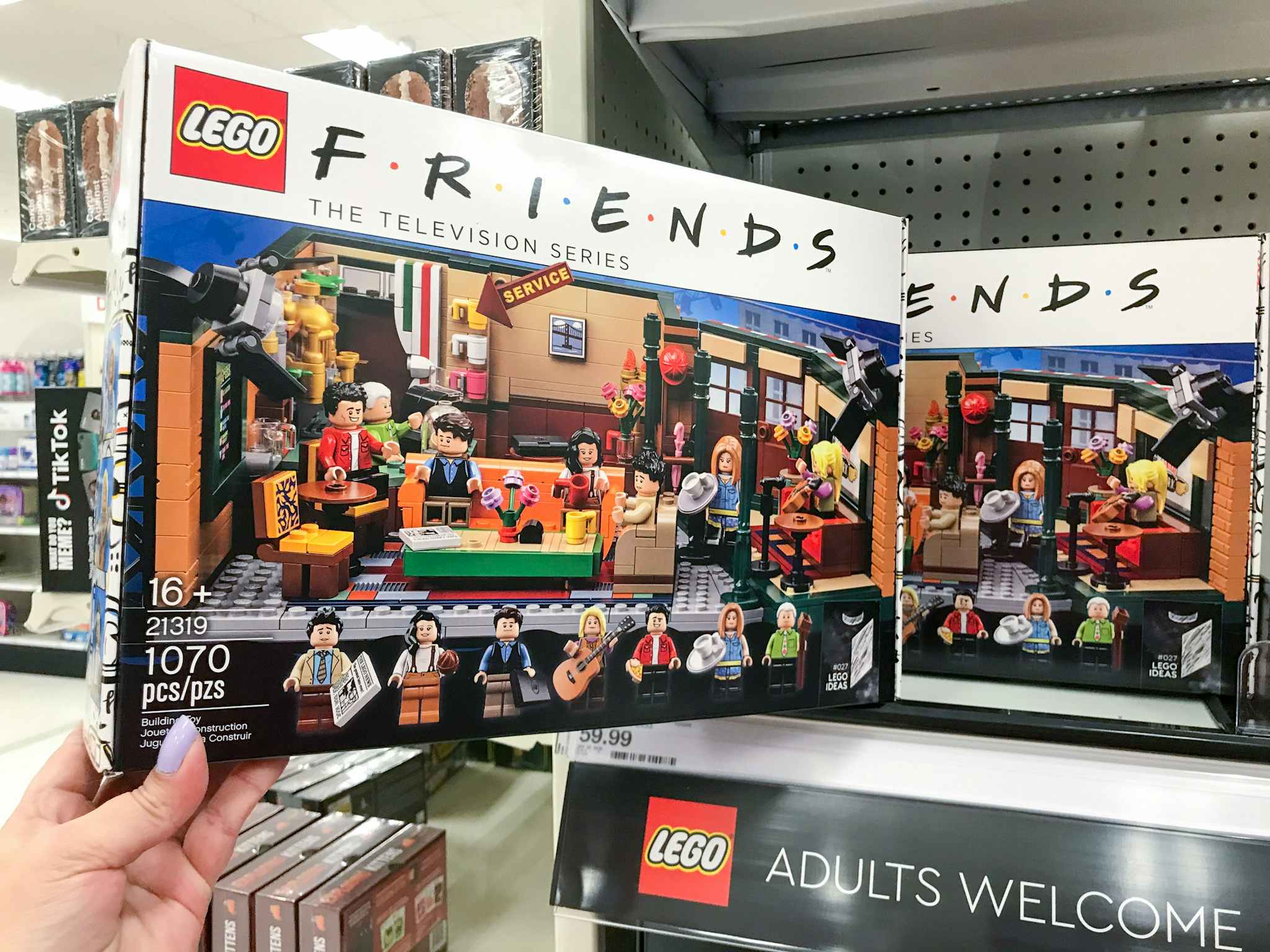 hand grabbing a lego friends central perk cafe building set off a target shelf