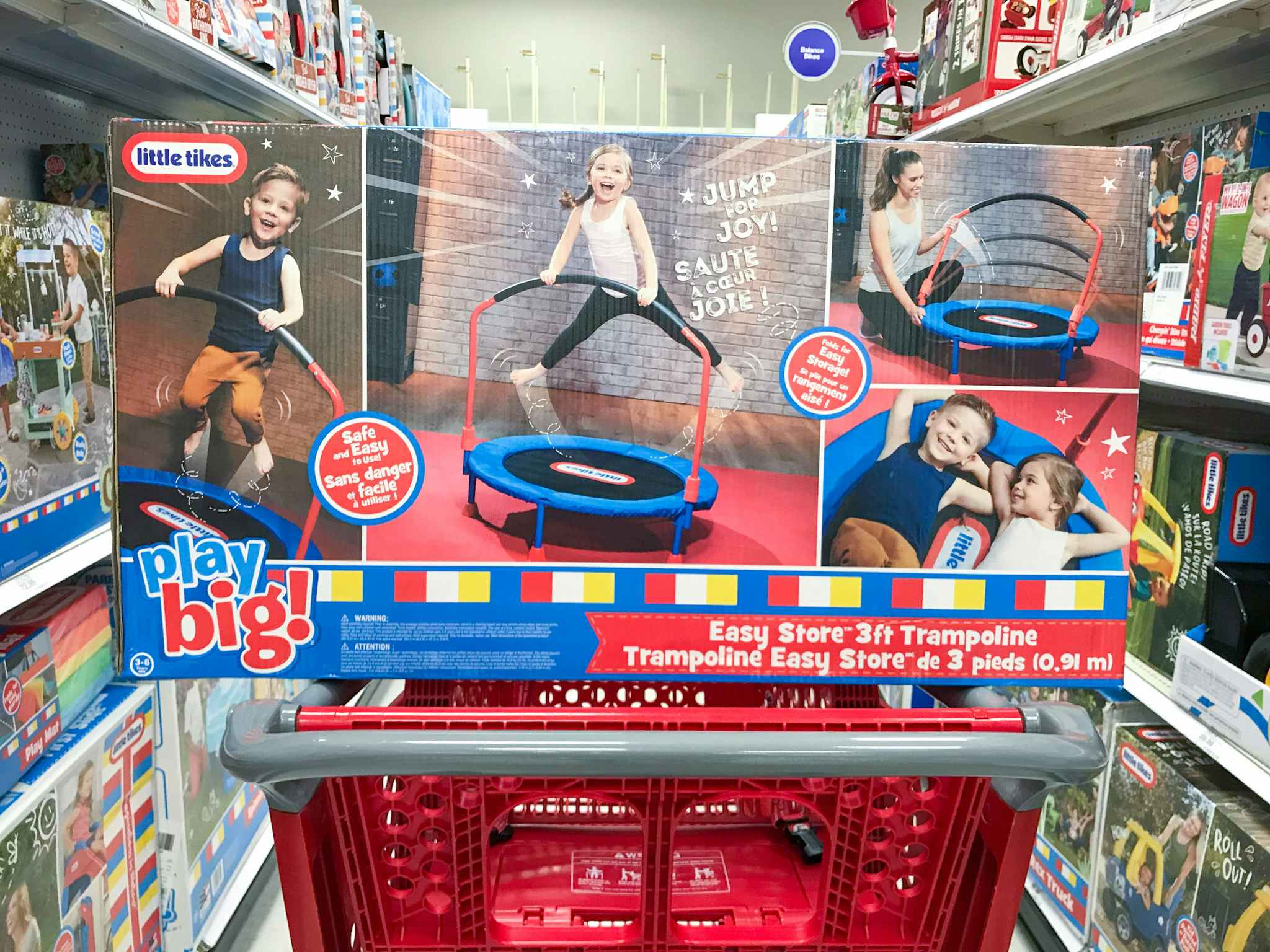 The box for a Little Tikes Easy Store 3ft Trampoline with a handle sitting on top of a Target shopping cart.